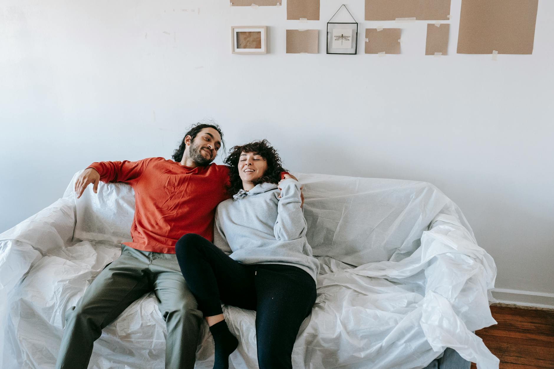 A happy couple enjoying a relaxed moment on a sofa in their home, symbolizing comfort and togetherness. - couples therapy new beginnings