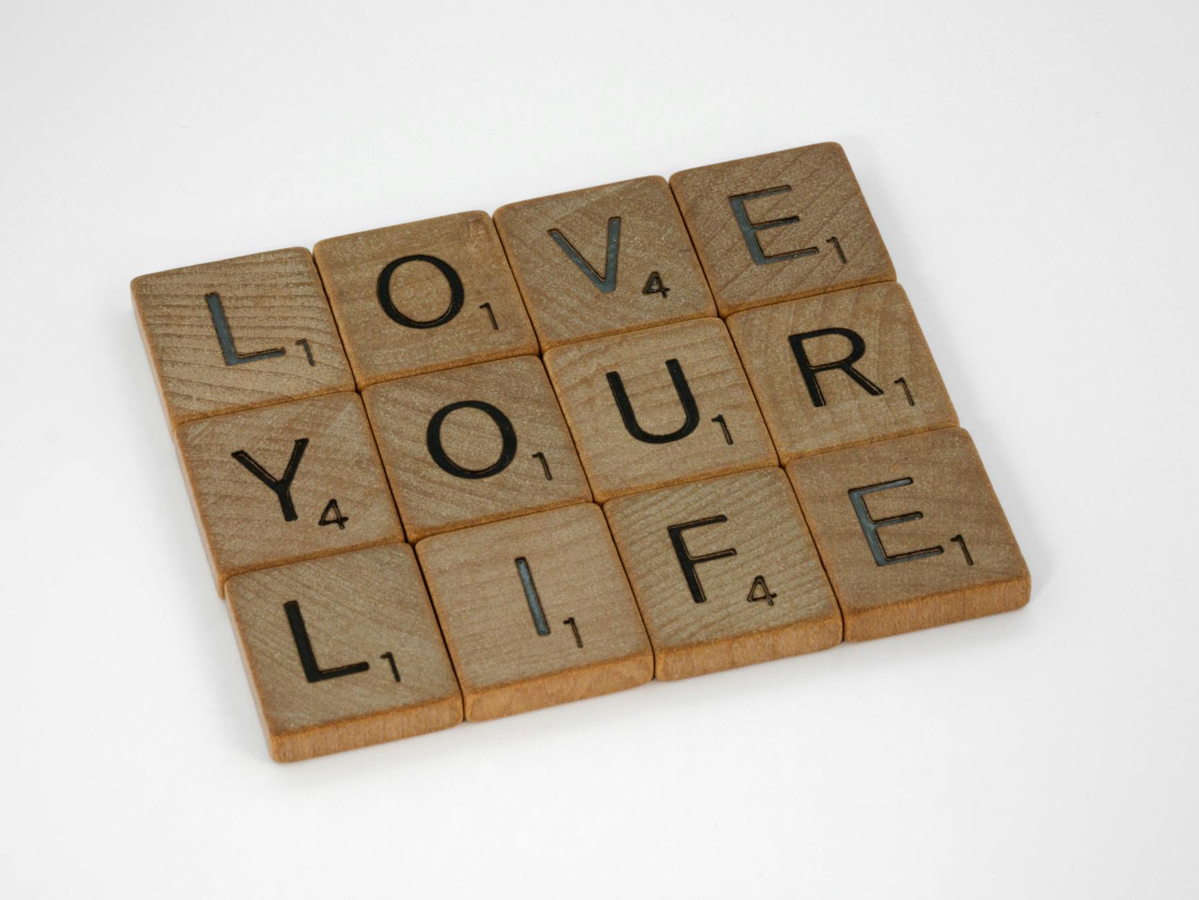 Scrabble tiles arranged to spell 'Love Your Life' against a white background, conveying a positive message. - declutter your mind