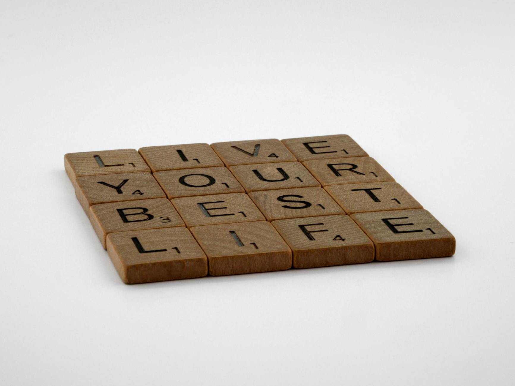Scrabble tiles spelling 'Live Your Best Life' on a white background. - declutter your mind