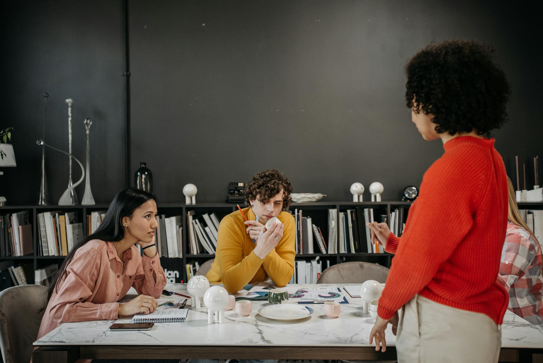 Team discussing projects at a table in a modern office setting. Engaged employees sharing ideas. - define assertive communication