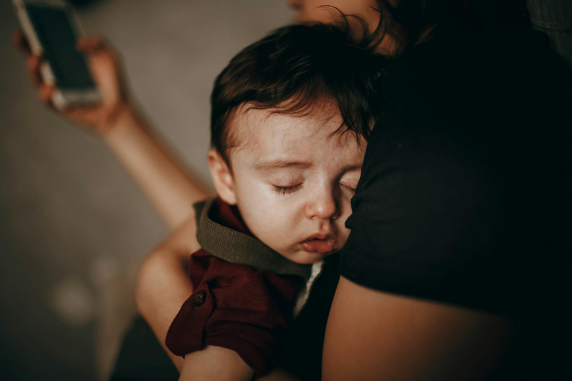 A tender moment captured as a child sleeps peacefully in their mother's embrace at home. - disorganized attachment