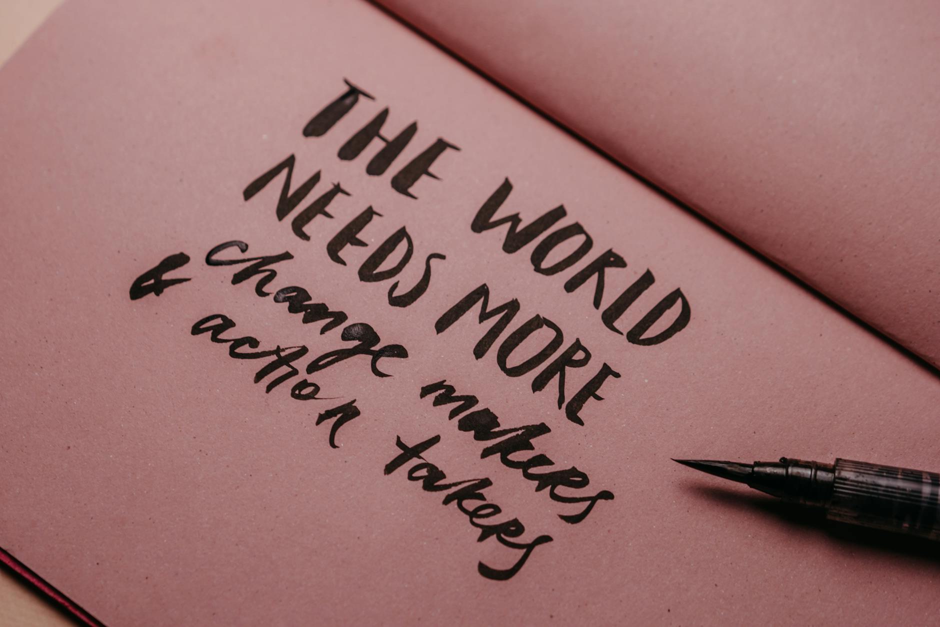 Close-up of a handwritten motivational quote on pink paper with a fountain pen. - express needs clearly