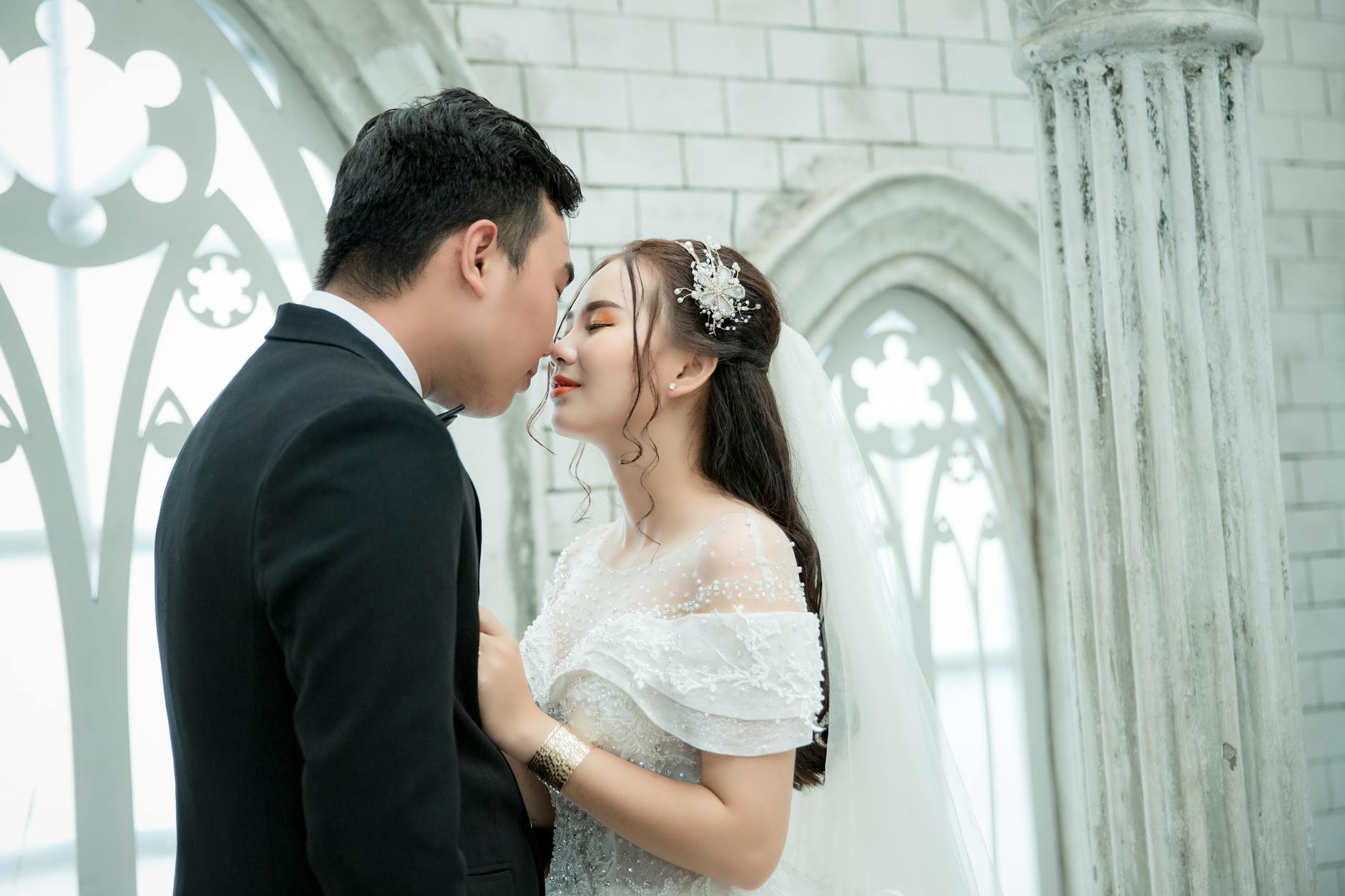 A romantic moment between a newlywed couple in an elegant indoor setting. - express needs marriage