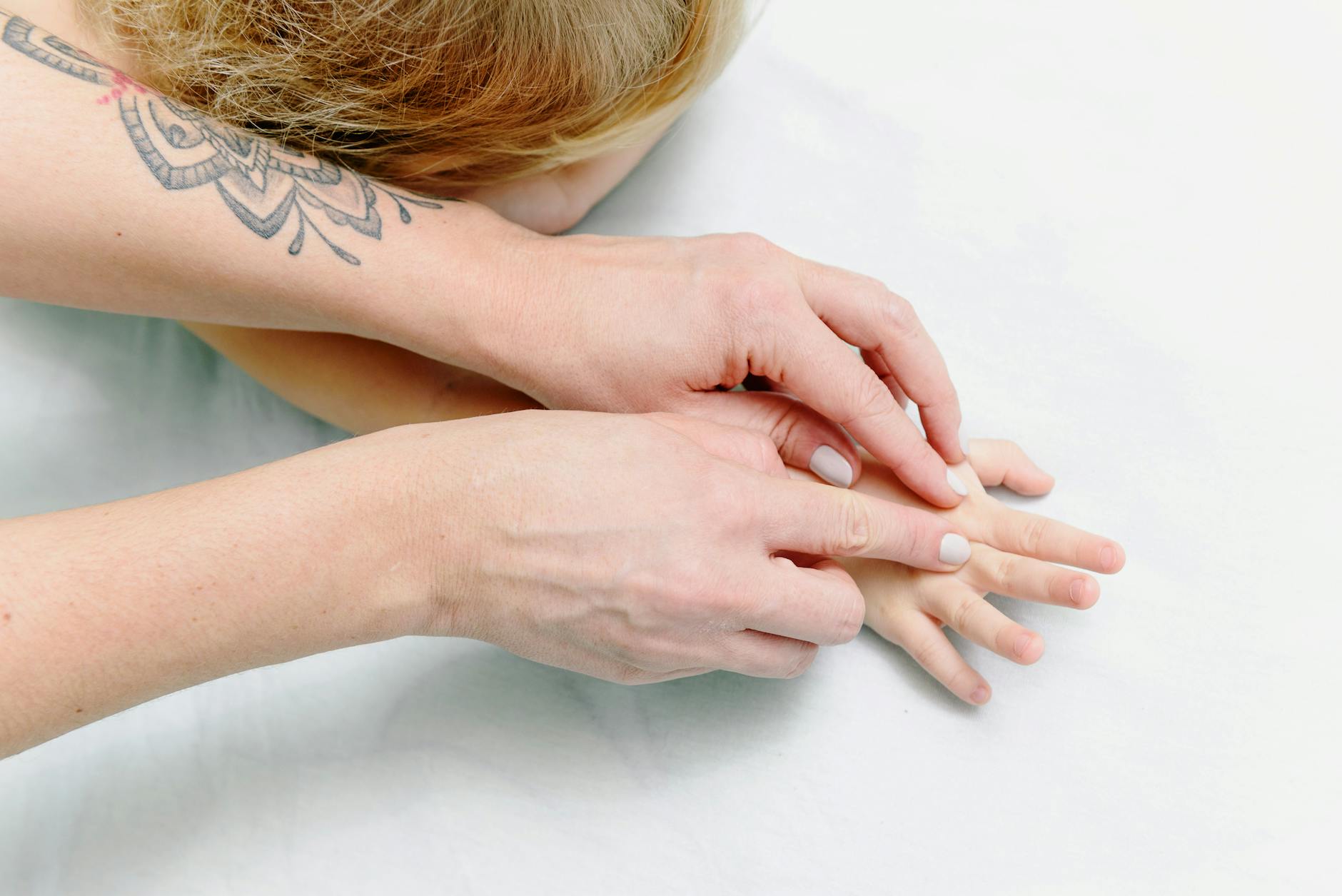 Close-up of a child receiving a comforting hand massage for relaxation and care. - family dynamics therapy