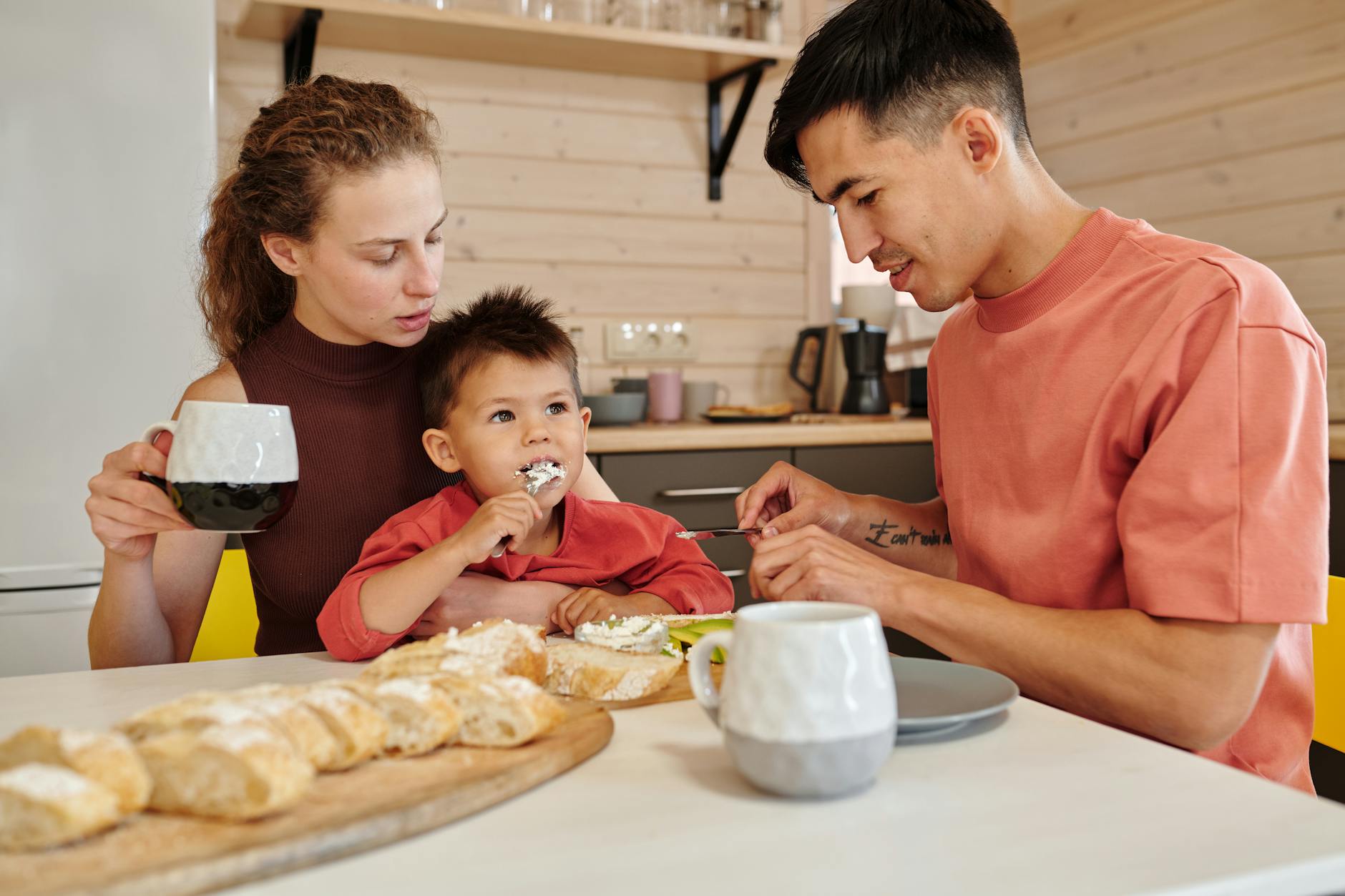 A family enjoys a cozy breakfast together, bonding over food and coffee in their kitchen. - family routines with kids