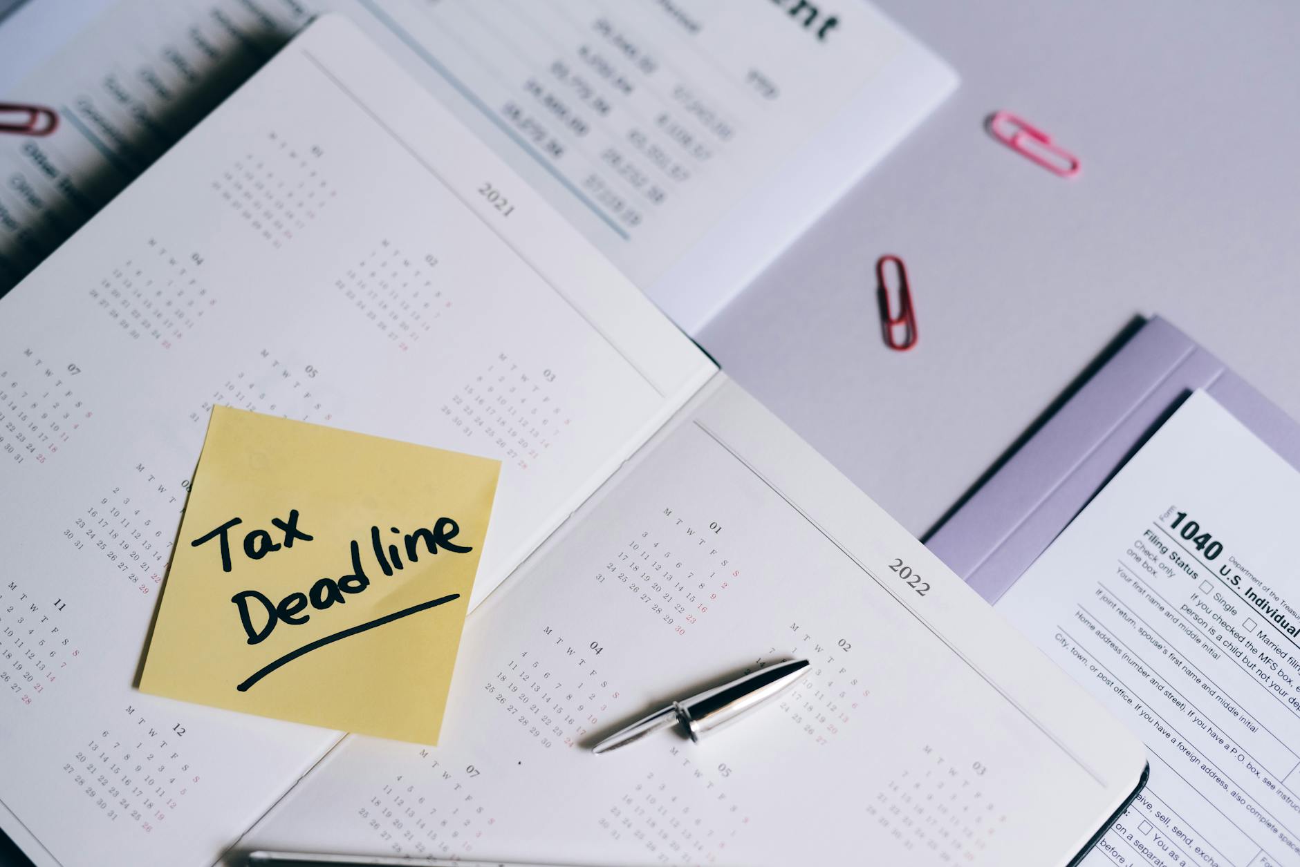 A calendar with a tax deadline note and tax forms, emphasizing organization. - first message online dating
