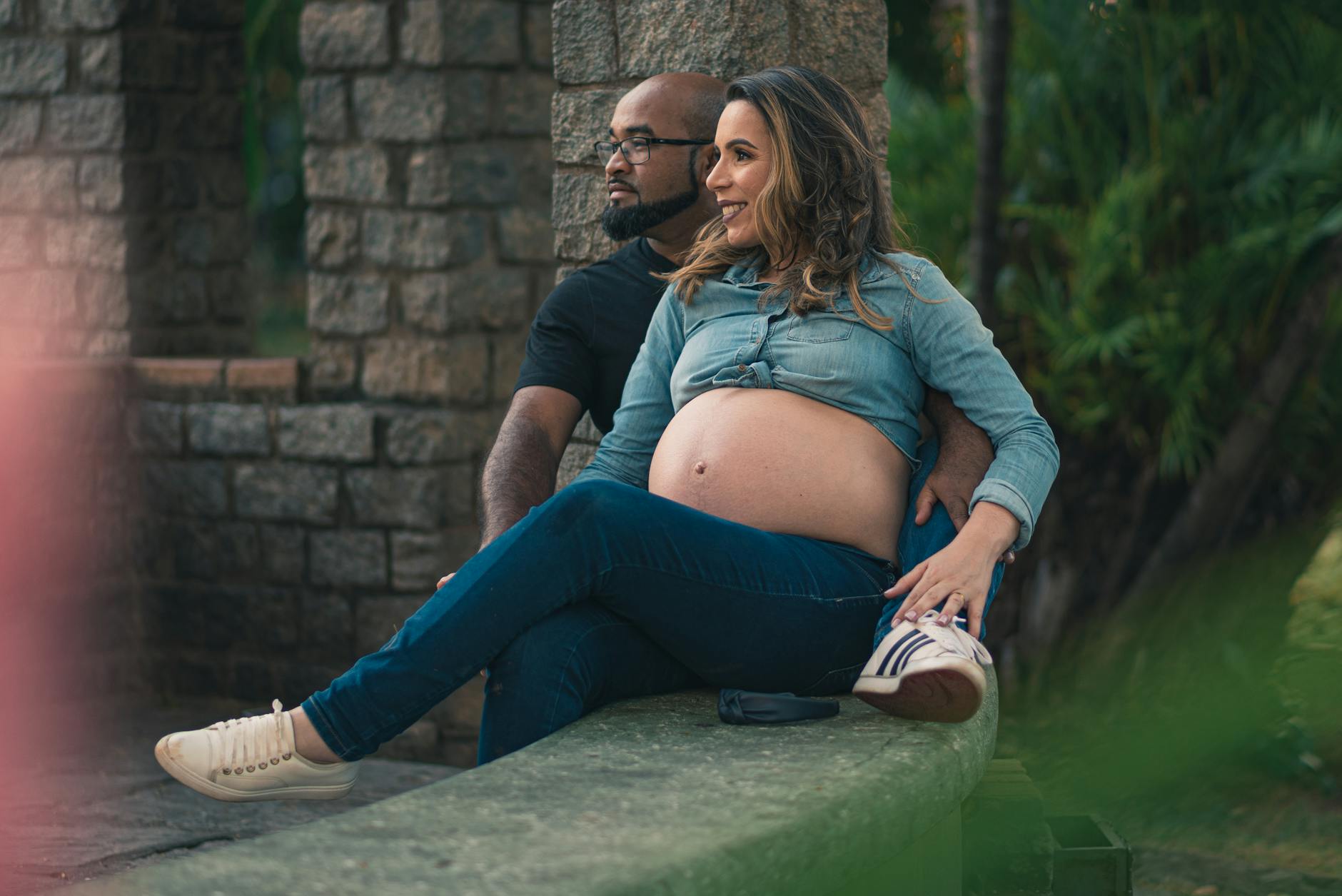 Pregnant woman and partner relaxing outside, showcasing love and anticipation. - future goals partner