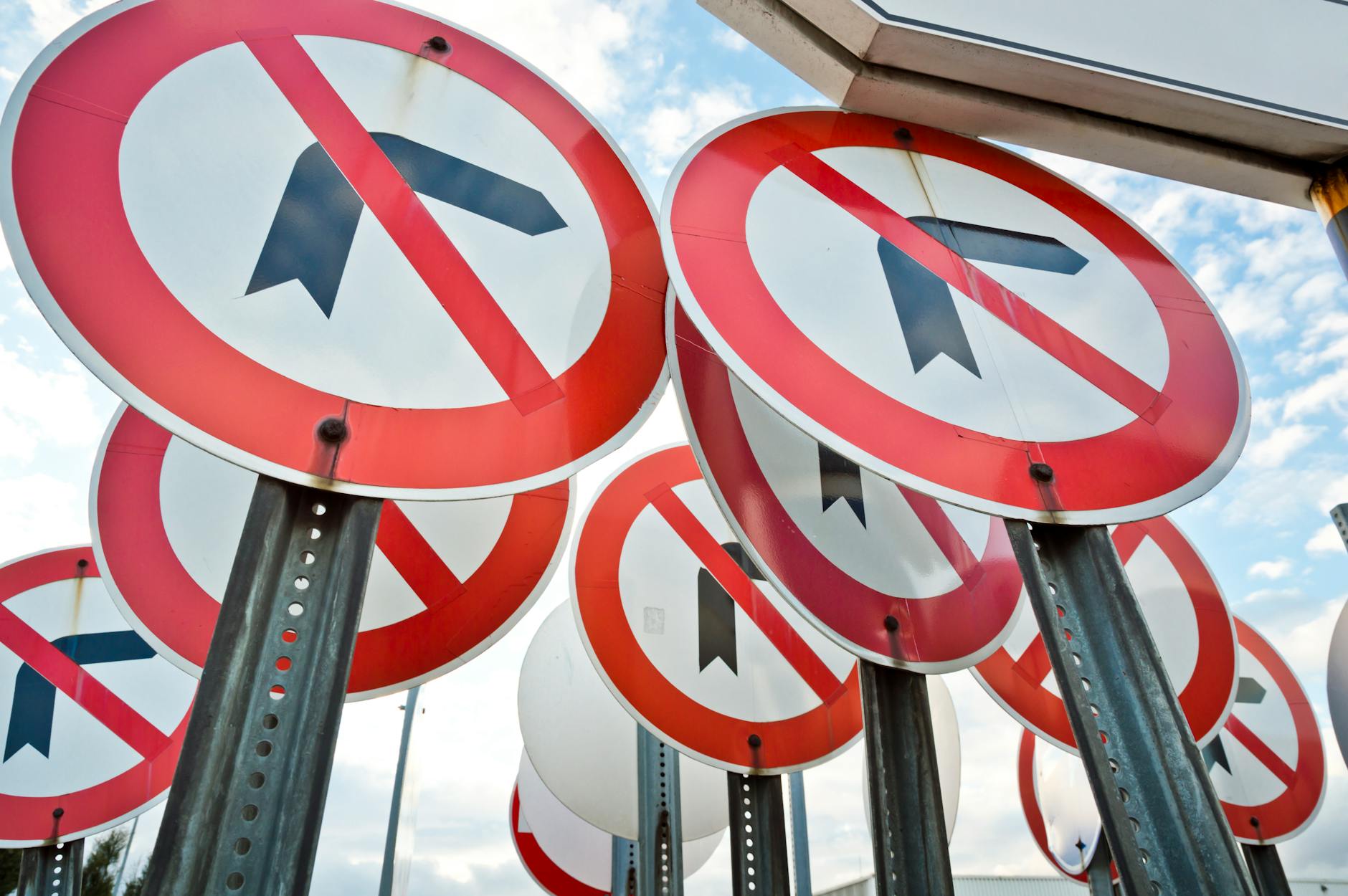 Multiple no left turn traffic signs displayed together under a blue sky. - gaslighting signs
