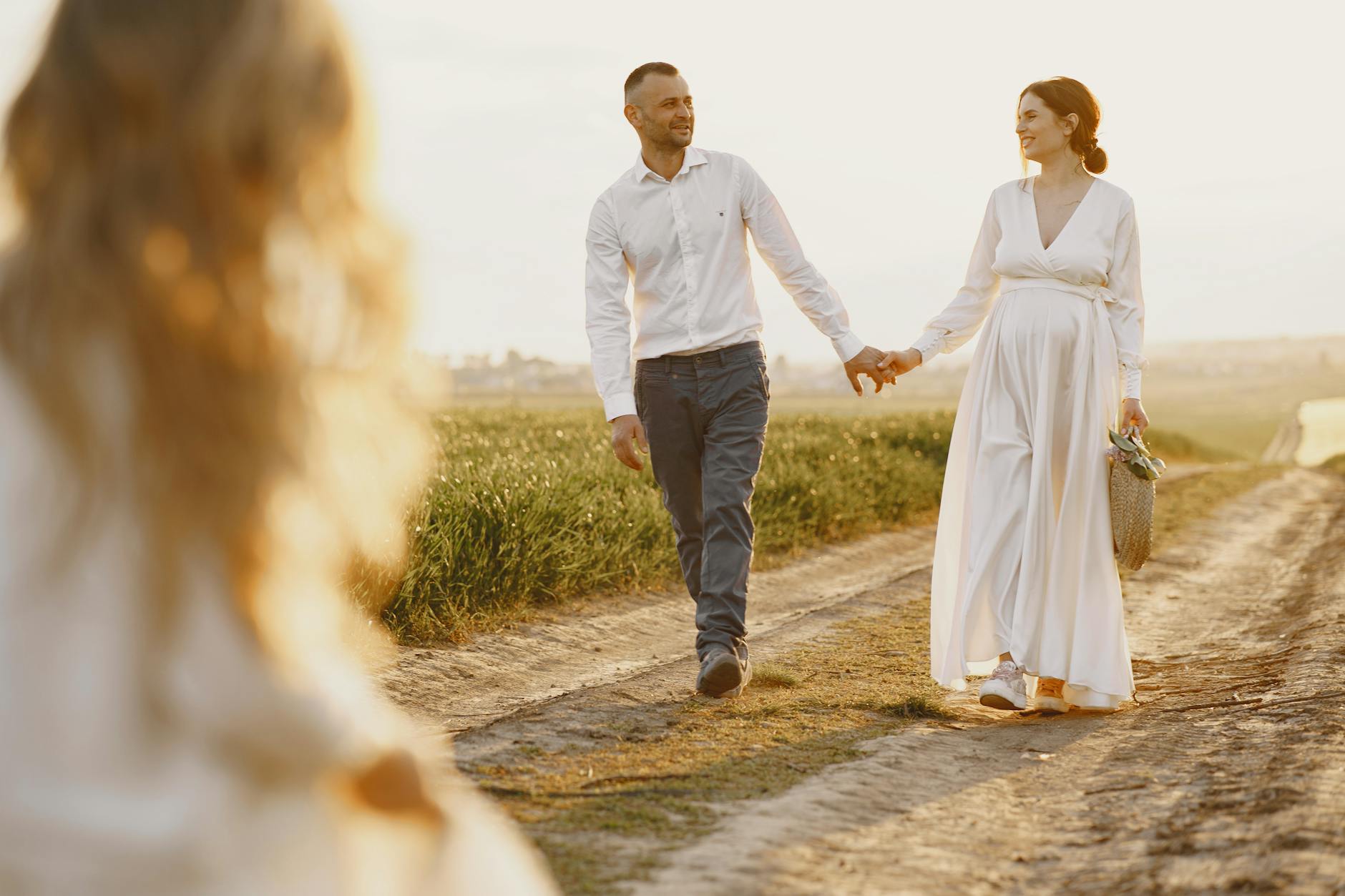 A couple holding hands, walking on a rural path at sunset, capturing a romantic and serene moment. - gratitude in marriage