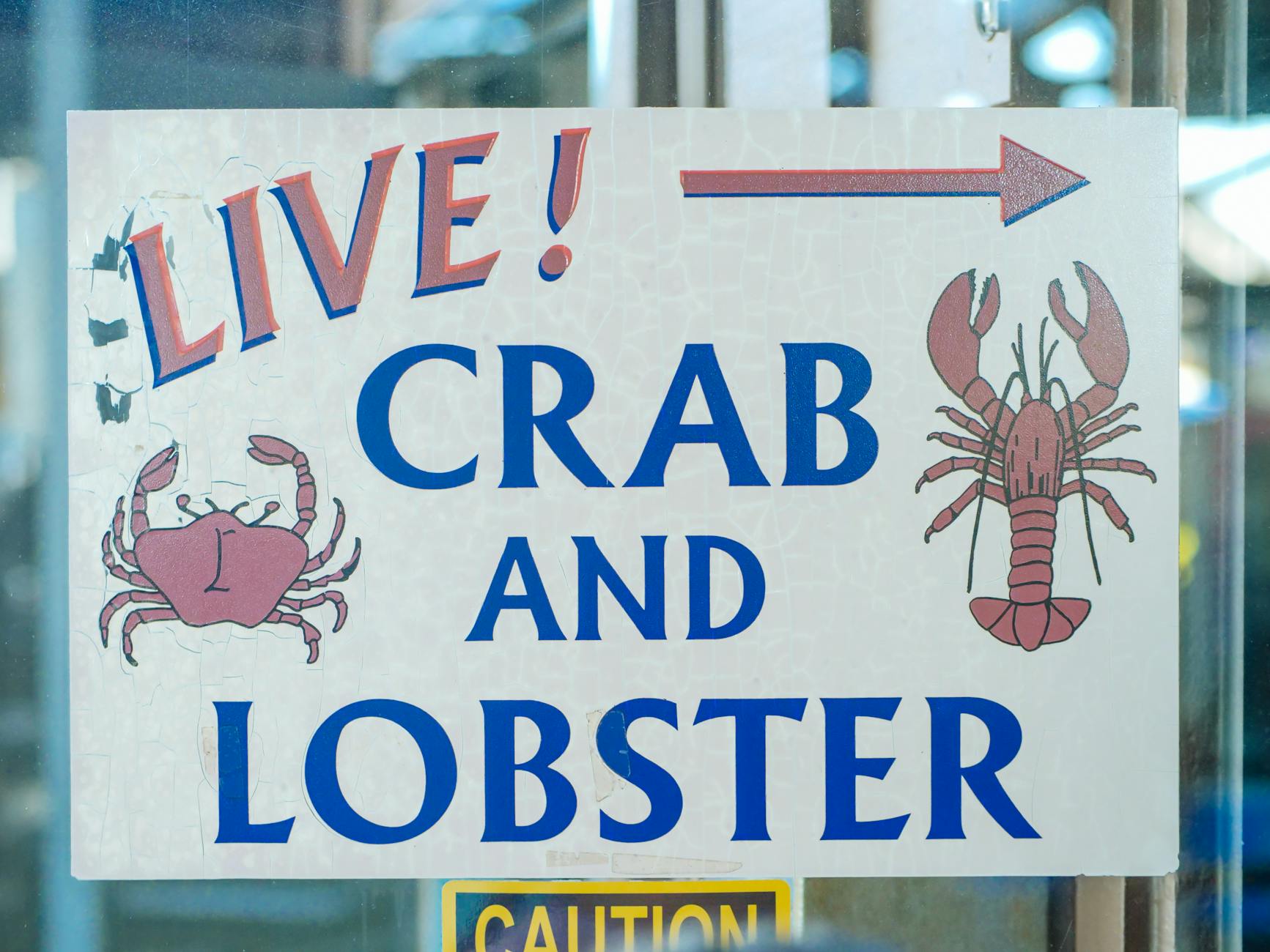 Sign advertising live crab and lobster with colorful illustrations at a seafood market. - healthy relationship signs
