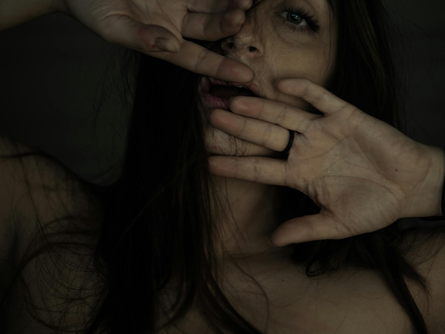 A close-up portrait capturing a young woman's emotive expression through hand gestures. - lack of empathy