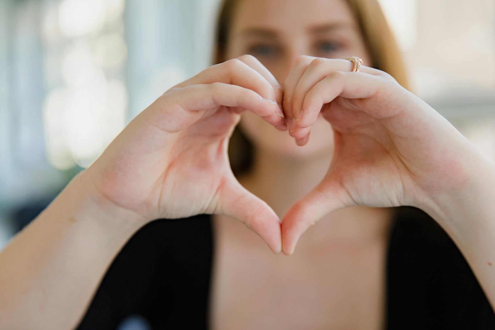 Close-up of a woman making a heart shape with her hands, symbolizing love. - love languages explained