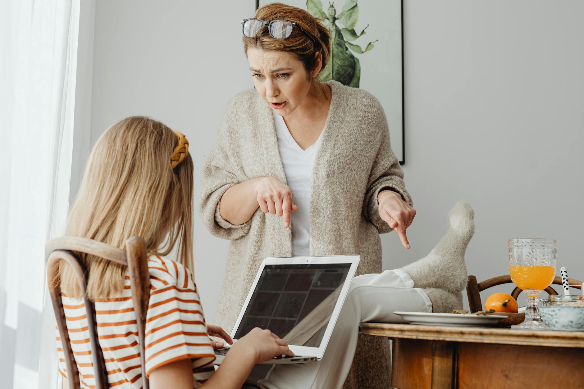 A mother scolds her teenage daughter using a laptop at home, highlighting a generational clash. - managing family conflict spring holidays