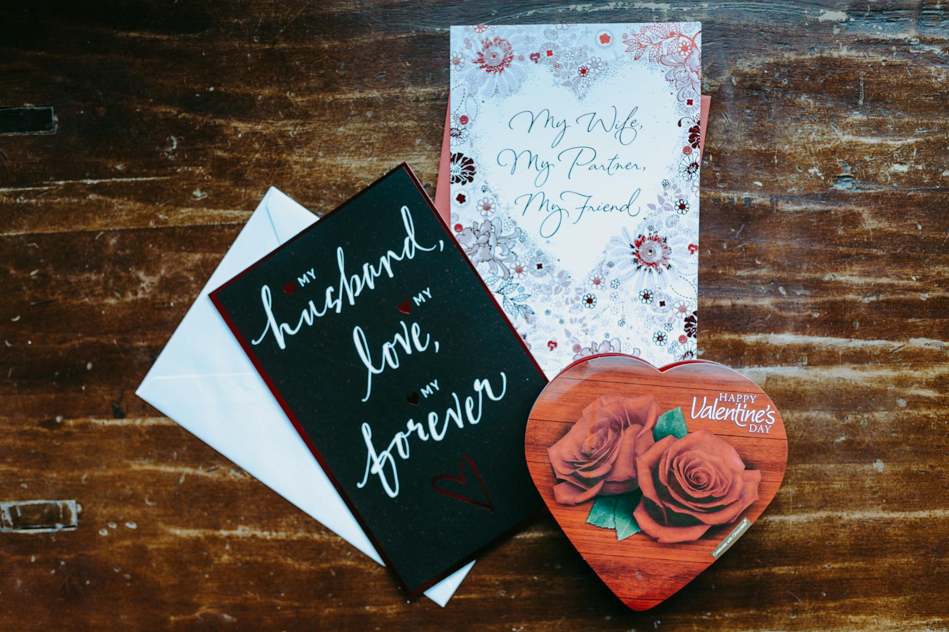 Heartfelt Valentine's Day cards and a heart-shaped chocolate box on a wooden surface, perfect for a romantic gift. - marriage advice cards