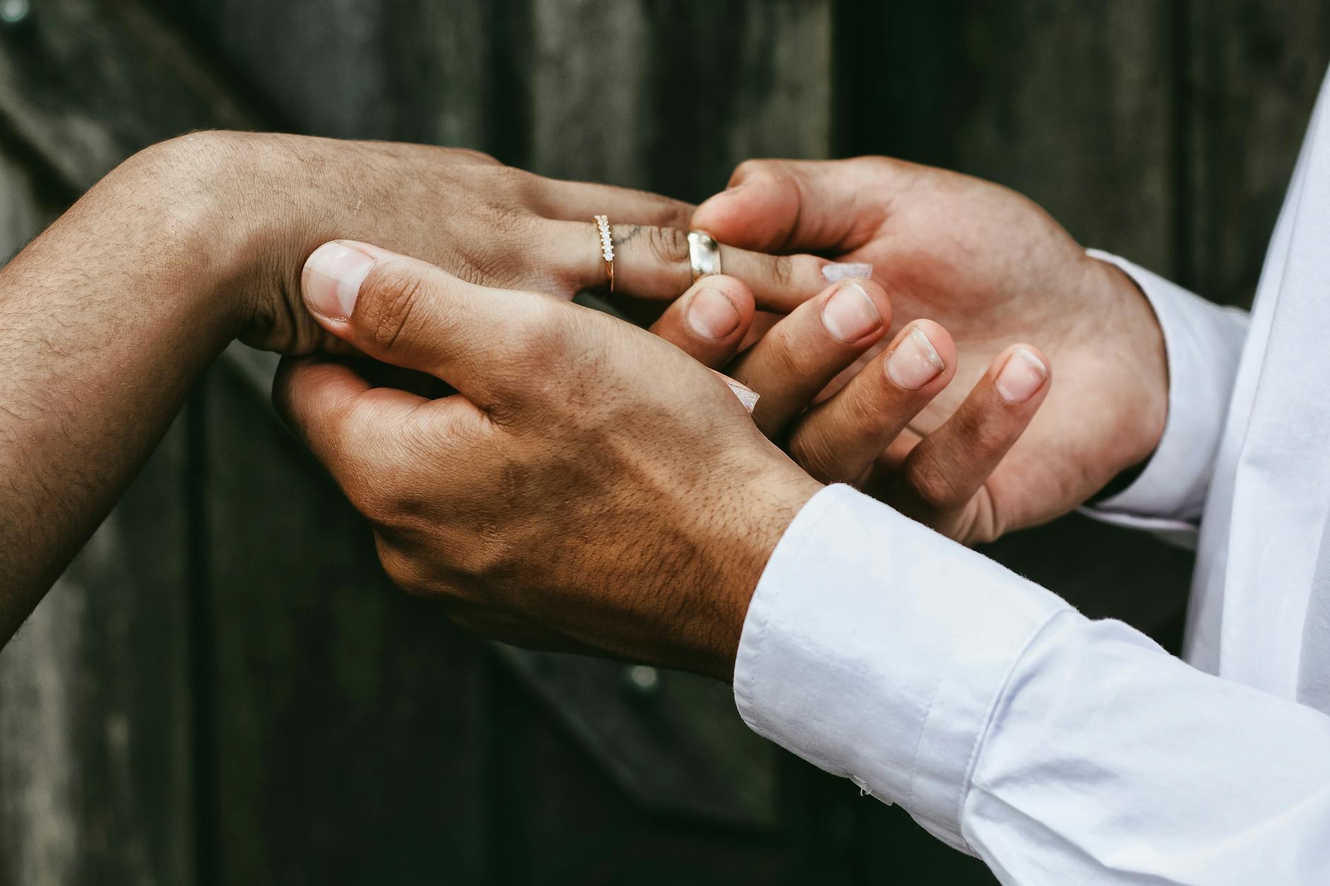 Close-up of a couple exchanging rings outdoors, symbolizing a loving commitment. - marriage communication tips