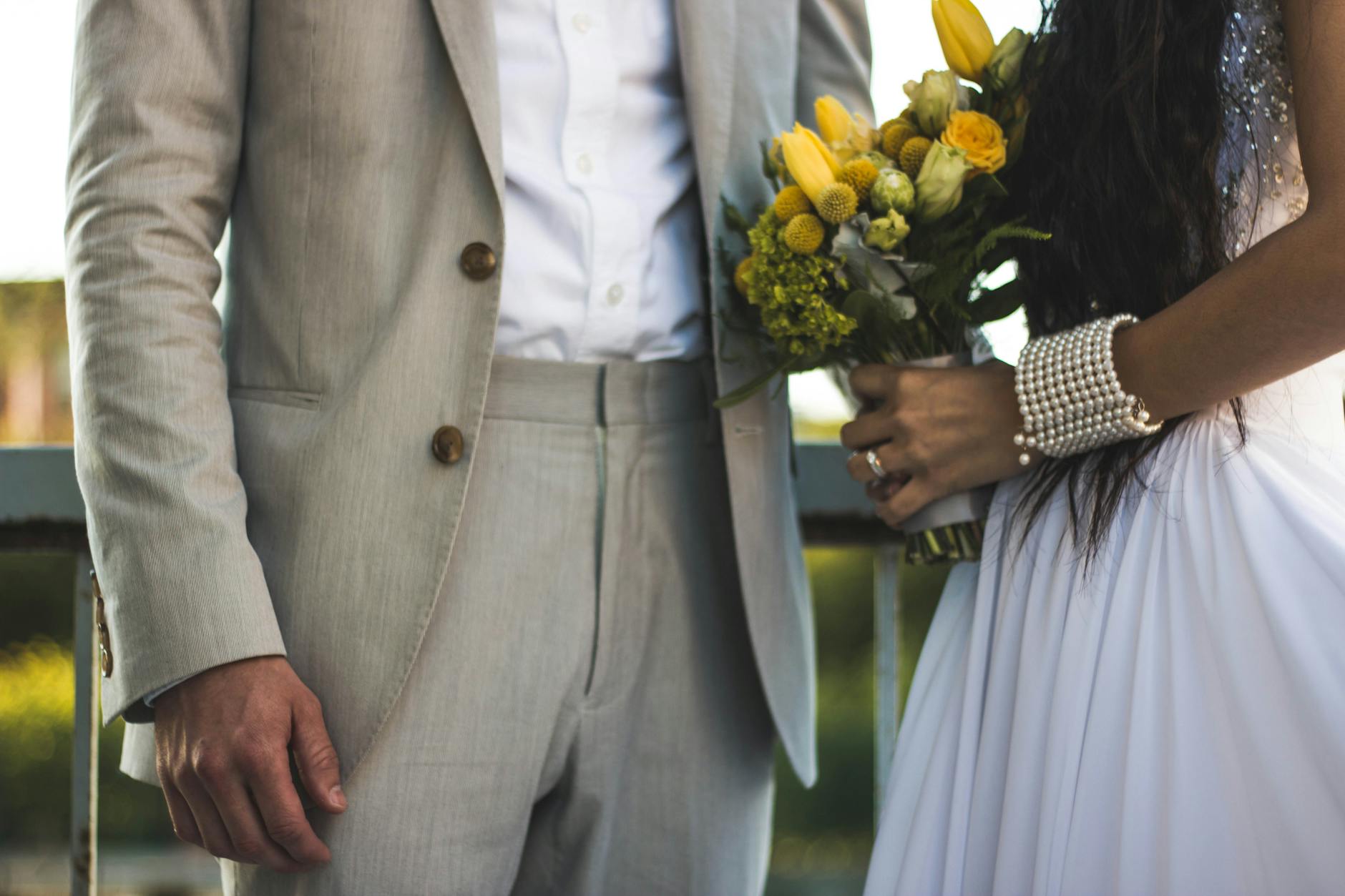 Close-up of a bride and groom with a yellow floral bouquet, showcasing elegance and love. - marriage communication tips