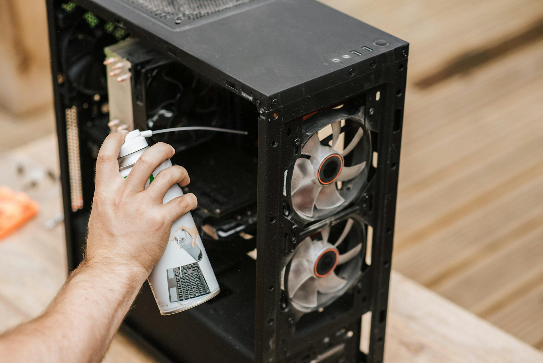 A person using compressed air to clean a computer case, focusing on dust removal. - marriage maintenance tips