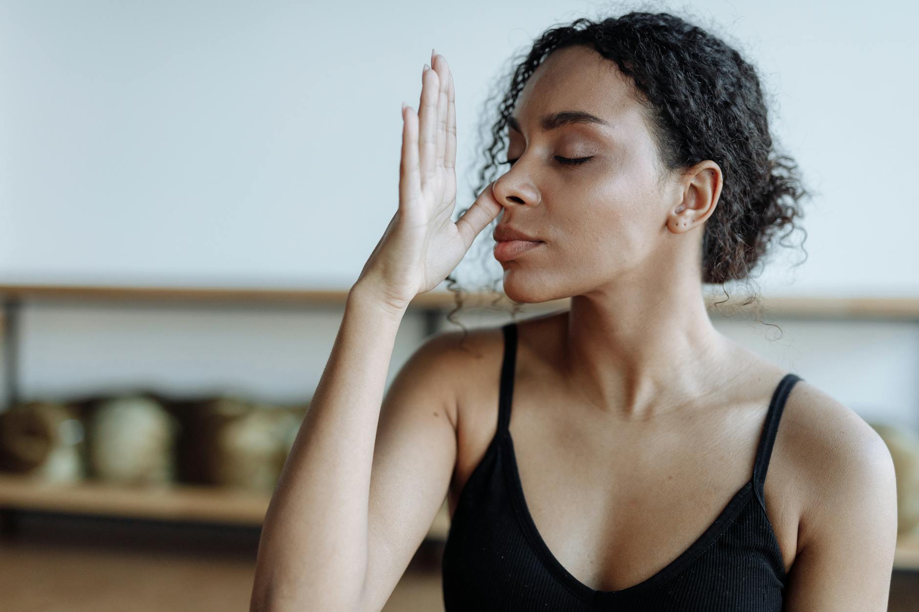 Close-up of a woman practicing yoga breathing techniques indoors, focusing on relaxation. - mental clarity techniques