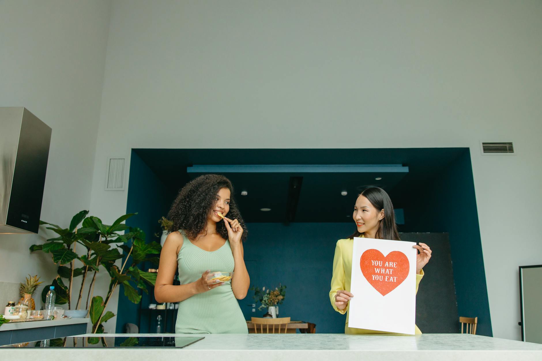 Two women enjoying healthy food and promoting nutrition awareness in a modern kitchen. - mindful eating winter wellness