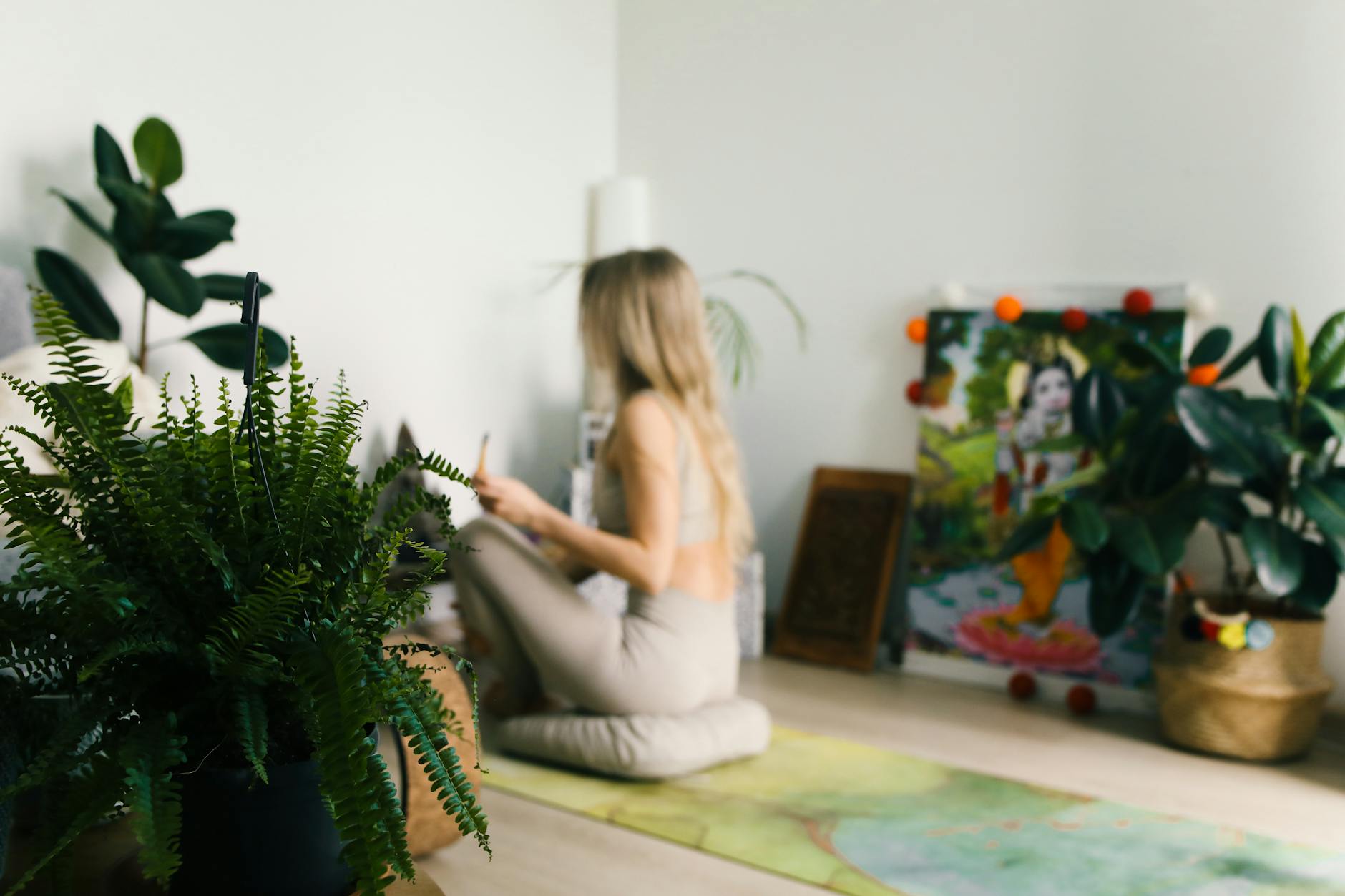 A woman practices meditation indoors surrounded by plants, promoting wellness and relaxation. - mindfulness for stress