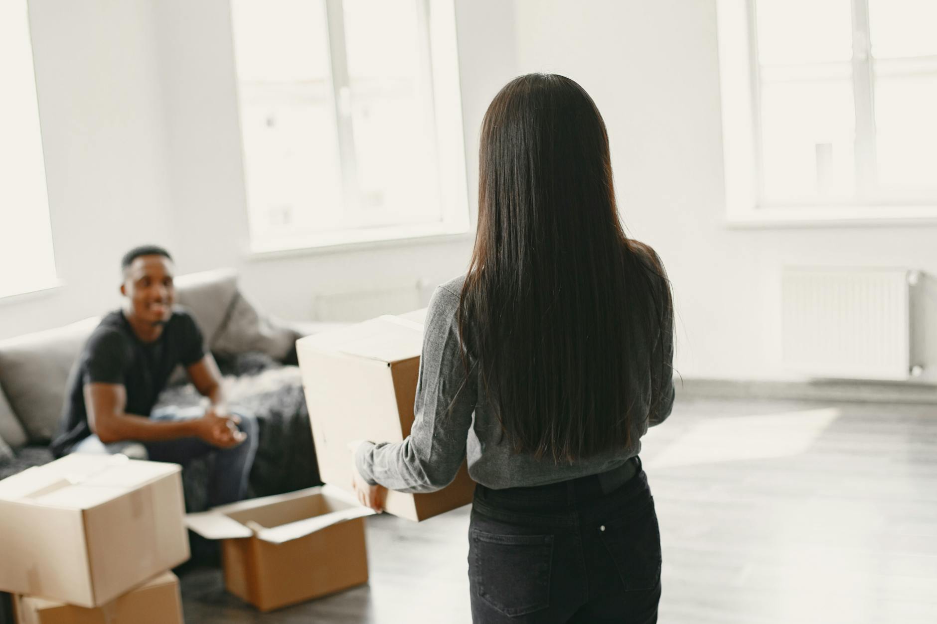 Couple unpacking cardboard boxes in their new apartment, symbolizing a fresh start and new beginnings. - new relationship growth
