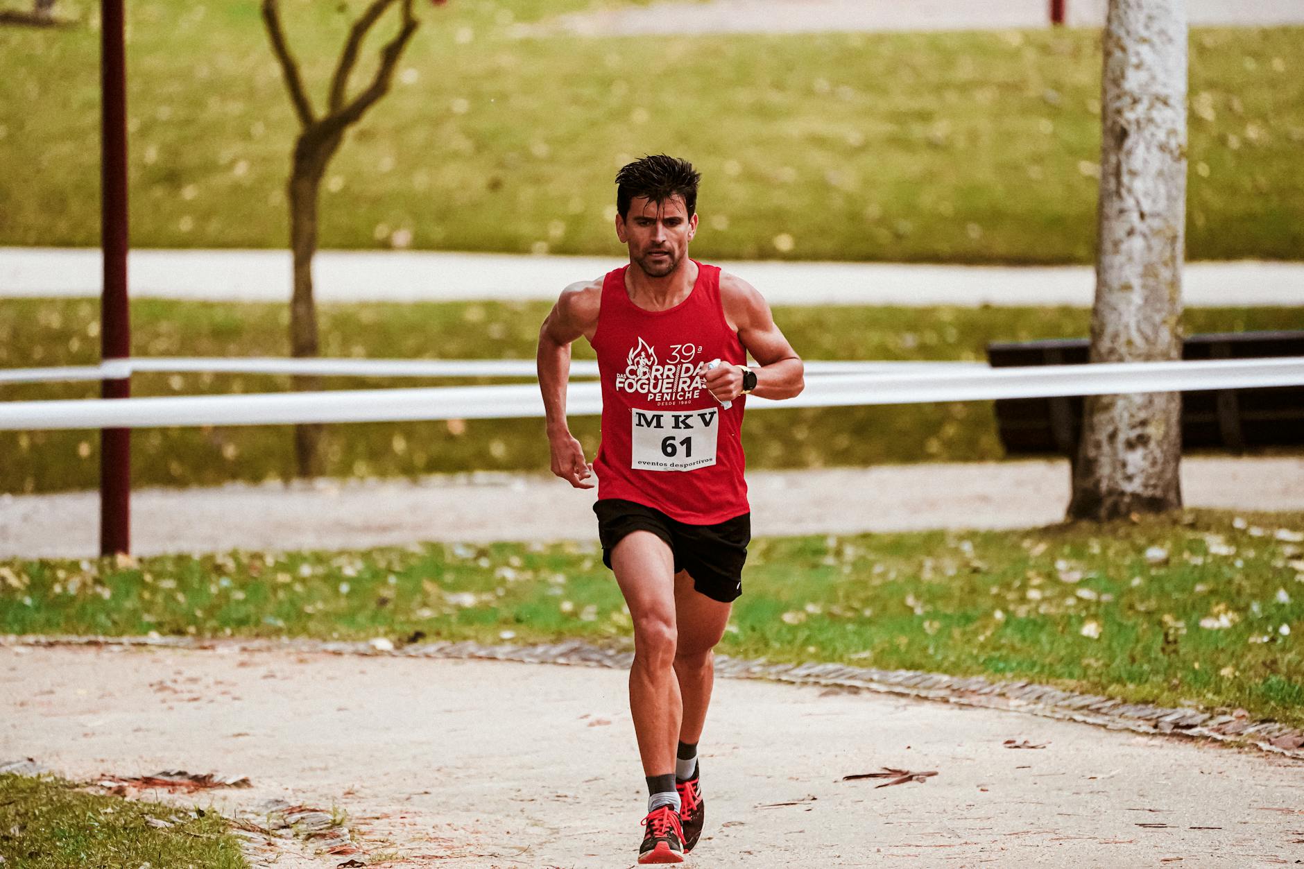 Focused runner participating in marathon race in park setting, showcasing determination and fitness. - outdoor play benefits