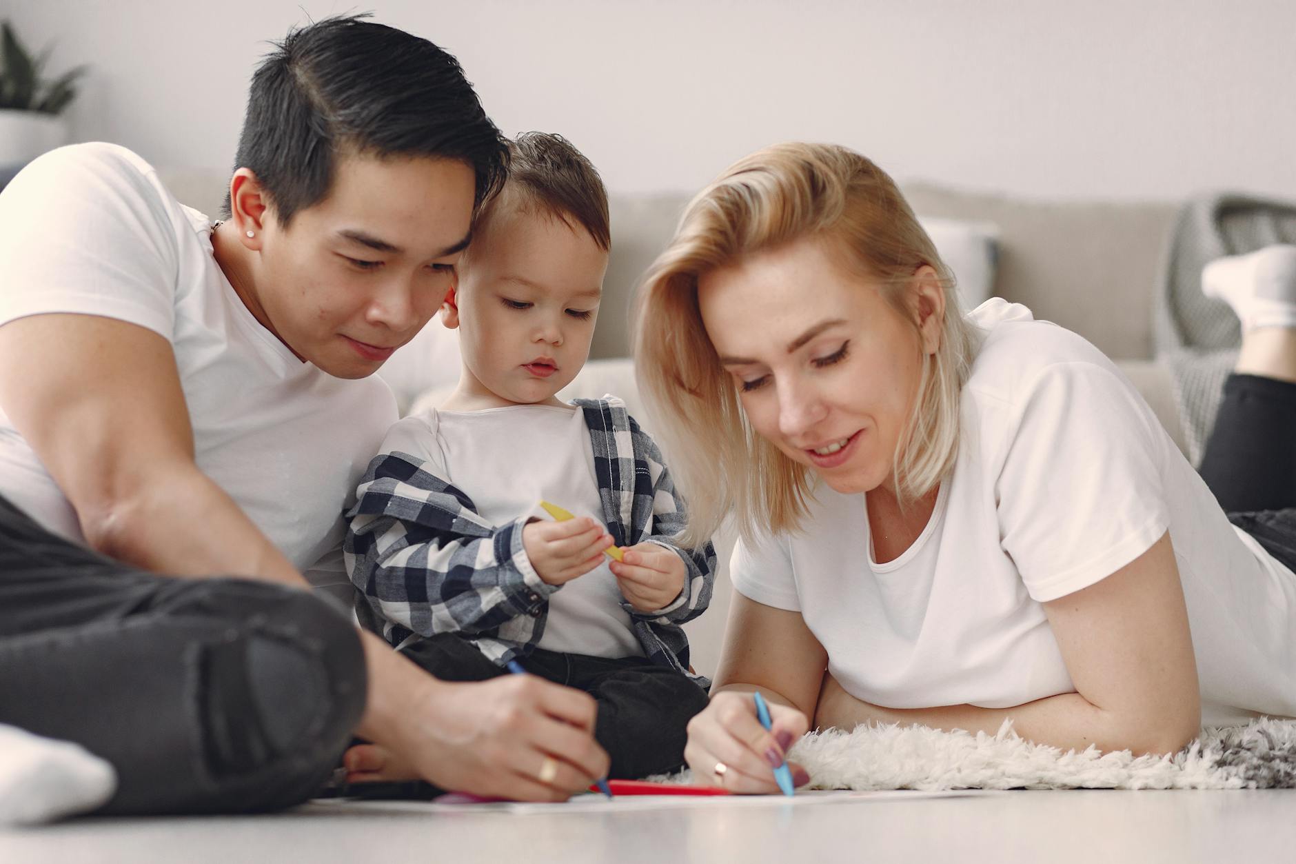 A family enjoys a fun and creative bonding session with drawing activities indoors. - post divorce co parenting