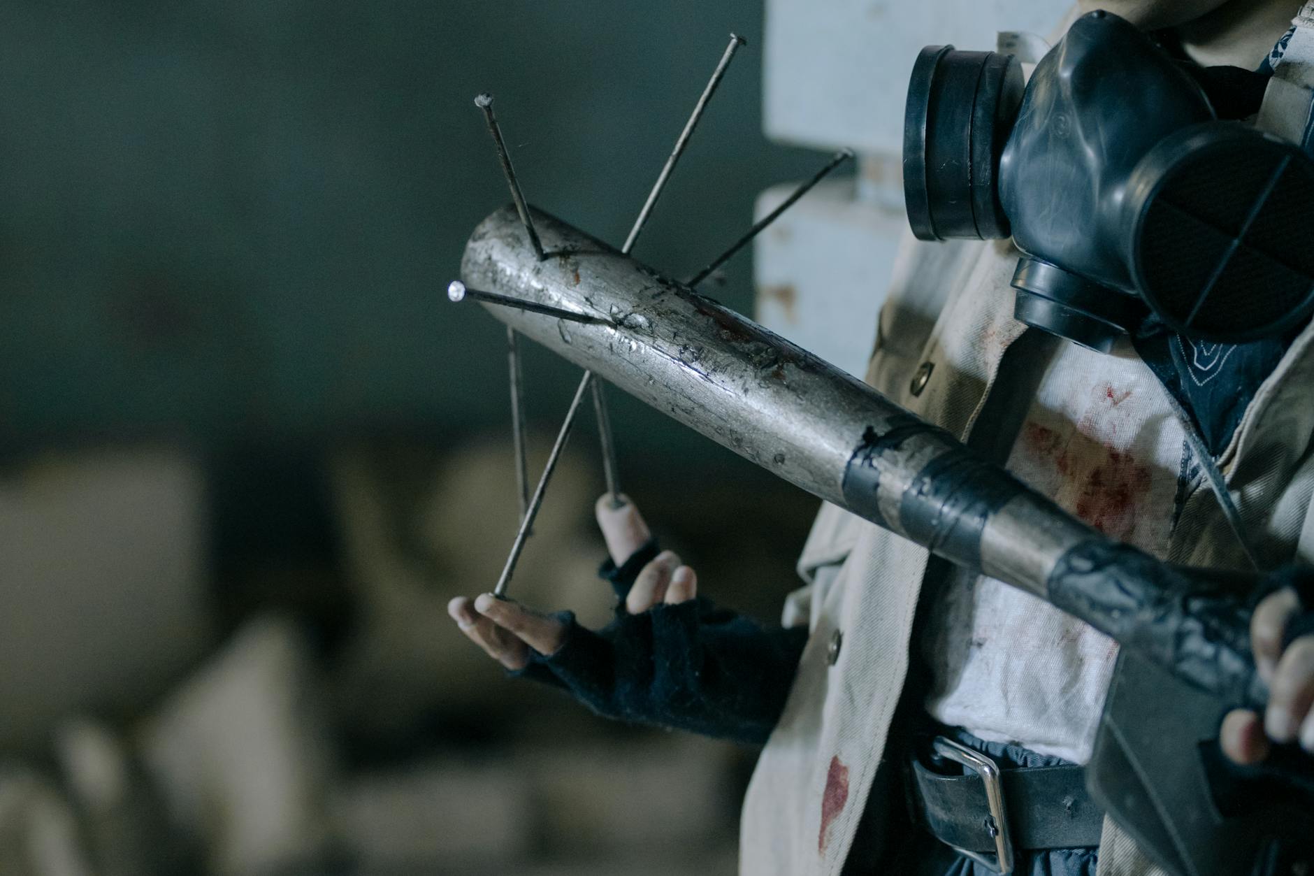 Close-up of a person with a gas mask holding a makeshift melee weapon in a post-apocalyptic setting. - post holiday relationship challenges