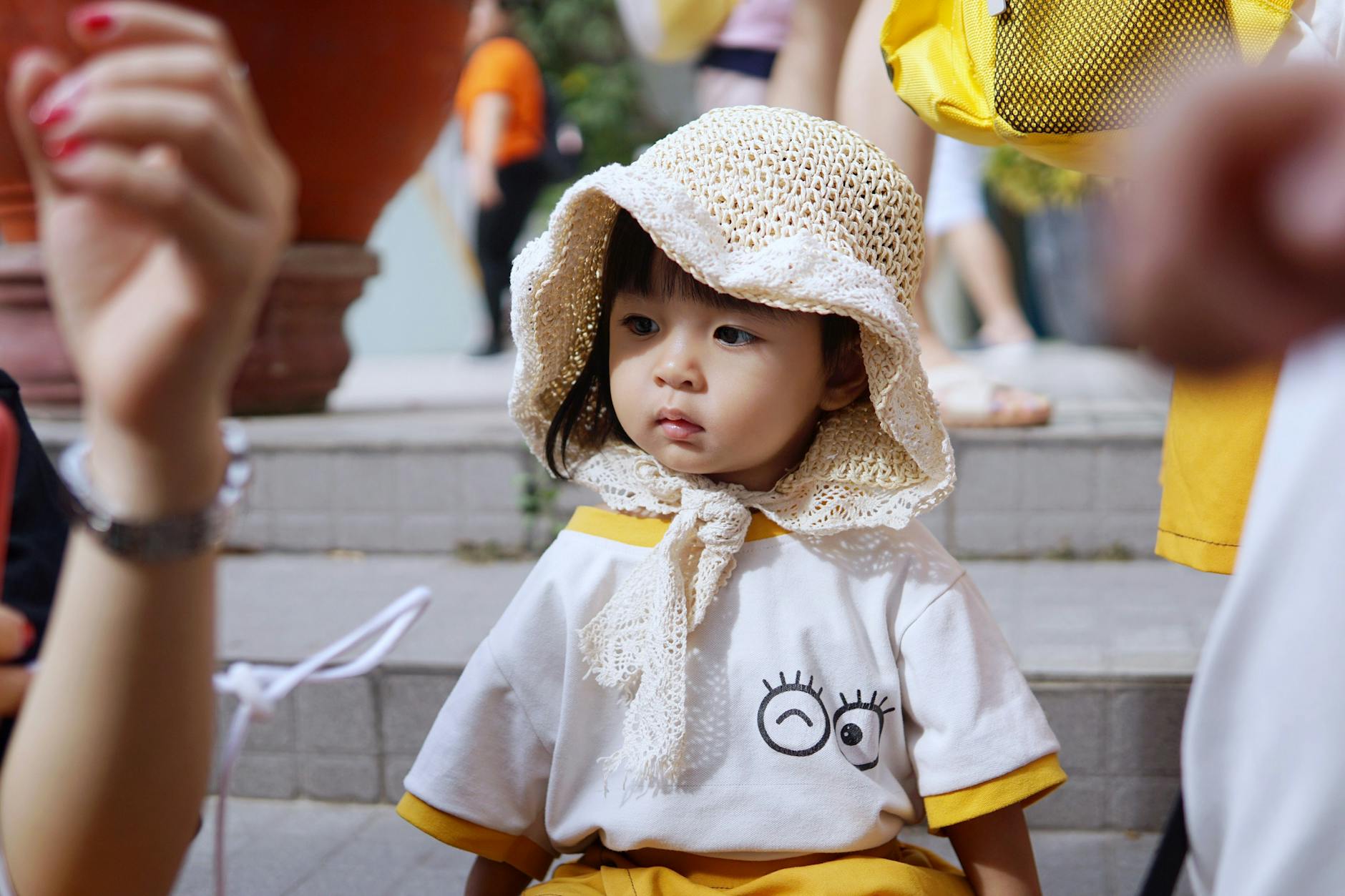 Cute little girl wearing a knitted hat and expressive t-shirt outdoors. - preschool playdate etiquette
