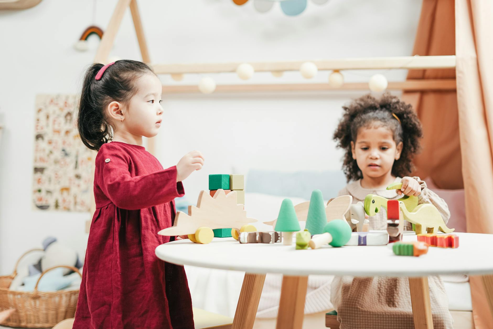 Two children engaging with wooden toys in a bright playroom. Ideal for education themes. - preschool social skills