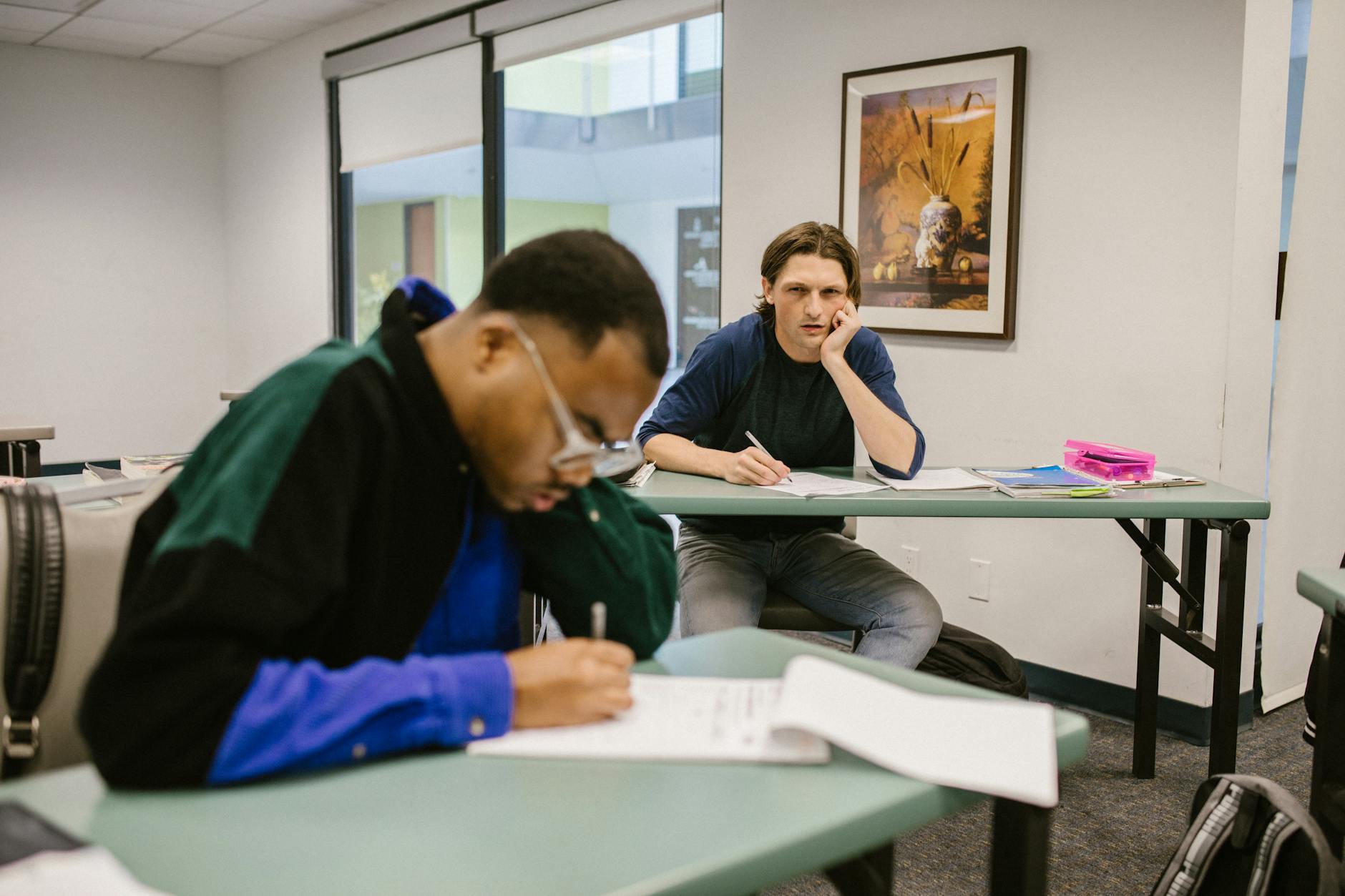 Two students focused during an exam in a classroom setting, highlighting diverse learning environments. - rebuilding trust cheating