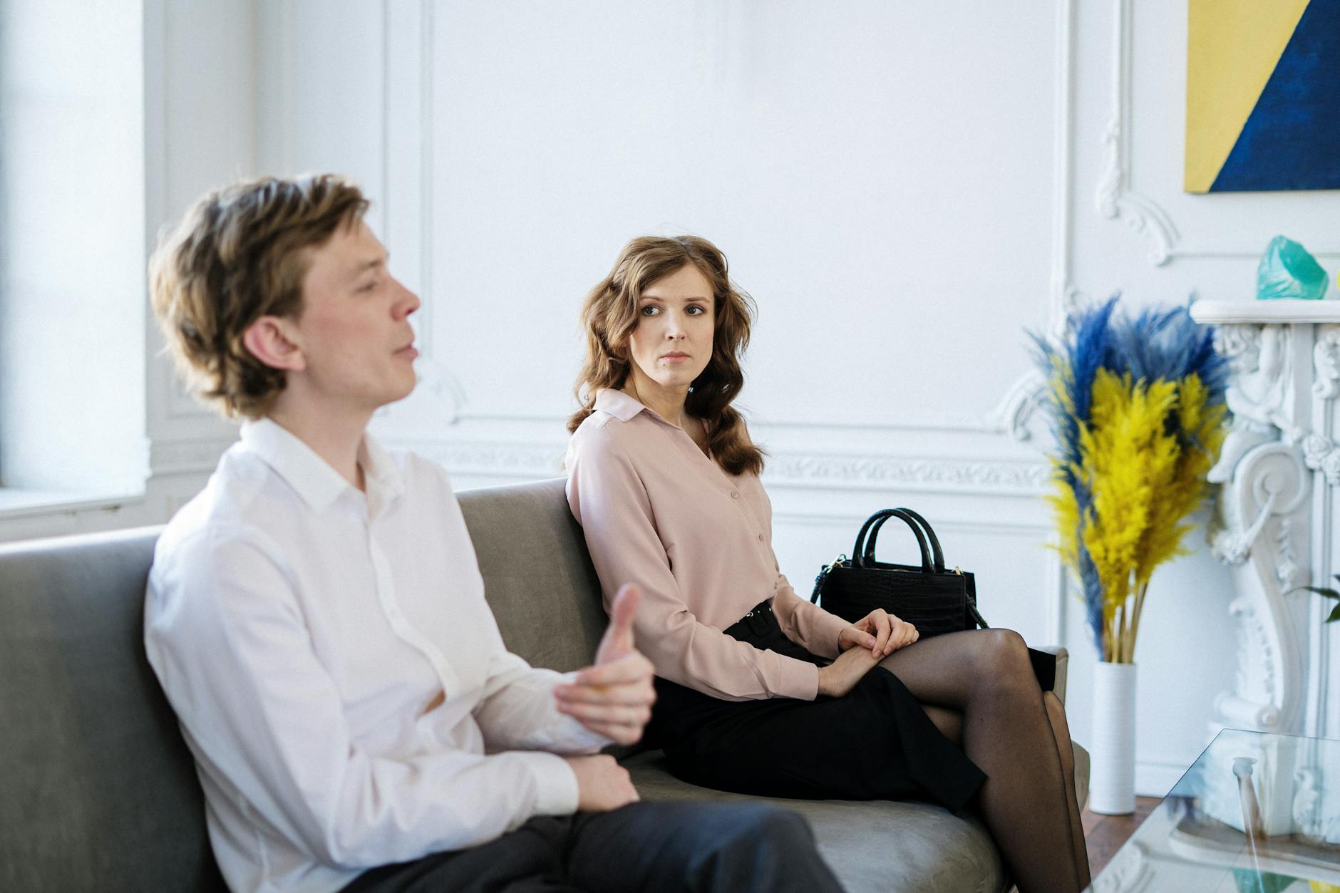 A couple sitting on a couch in a therapy session discussing relationship concerns. - reddit marriage advice