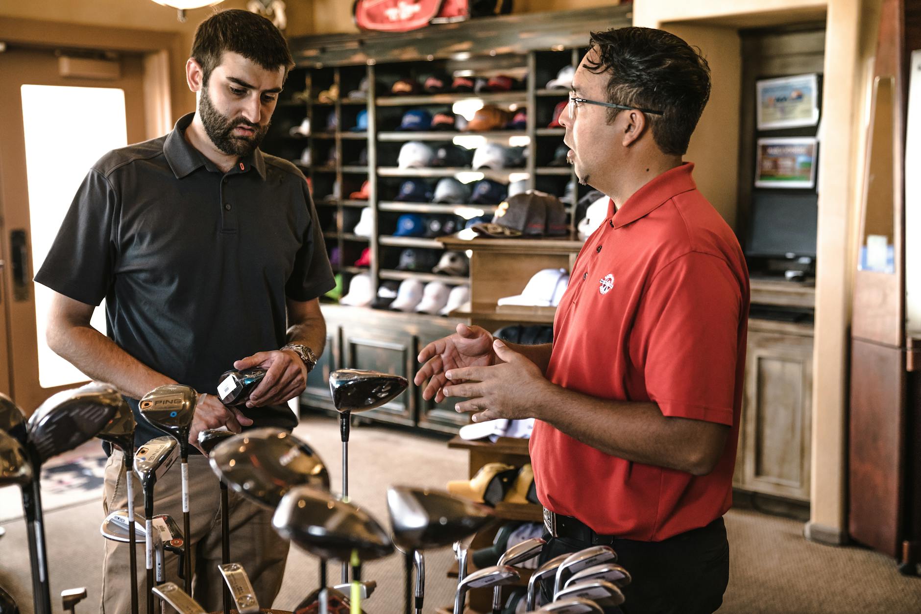 Customer receiving expert advice from salesman on golf equipment in a store. - reddit marriage advice