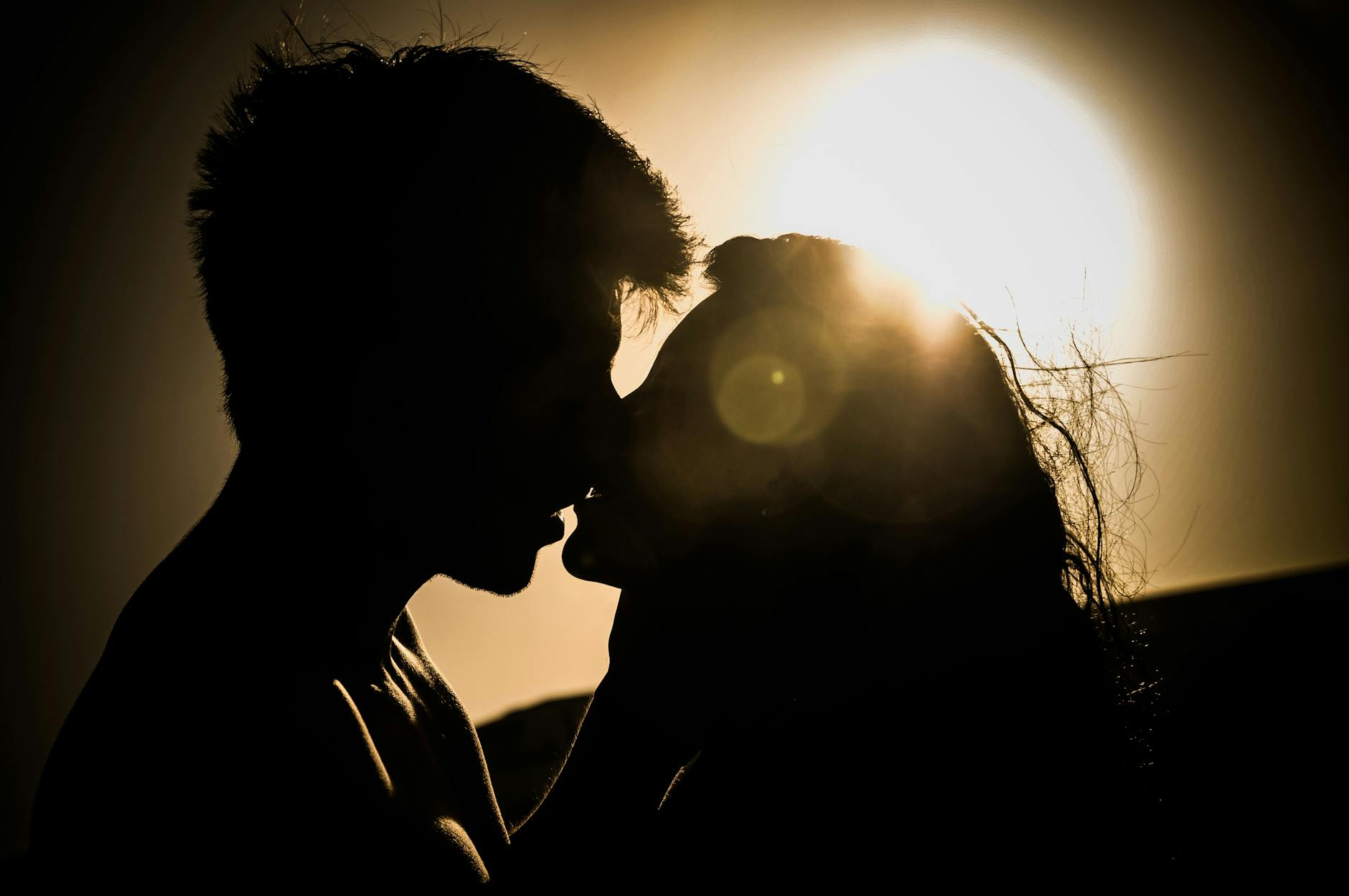 Silhouette of a couple kissing with the sun setting in the background, creating a romantic atmosphere. - reignite passion relationship
