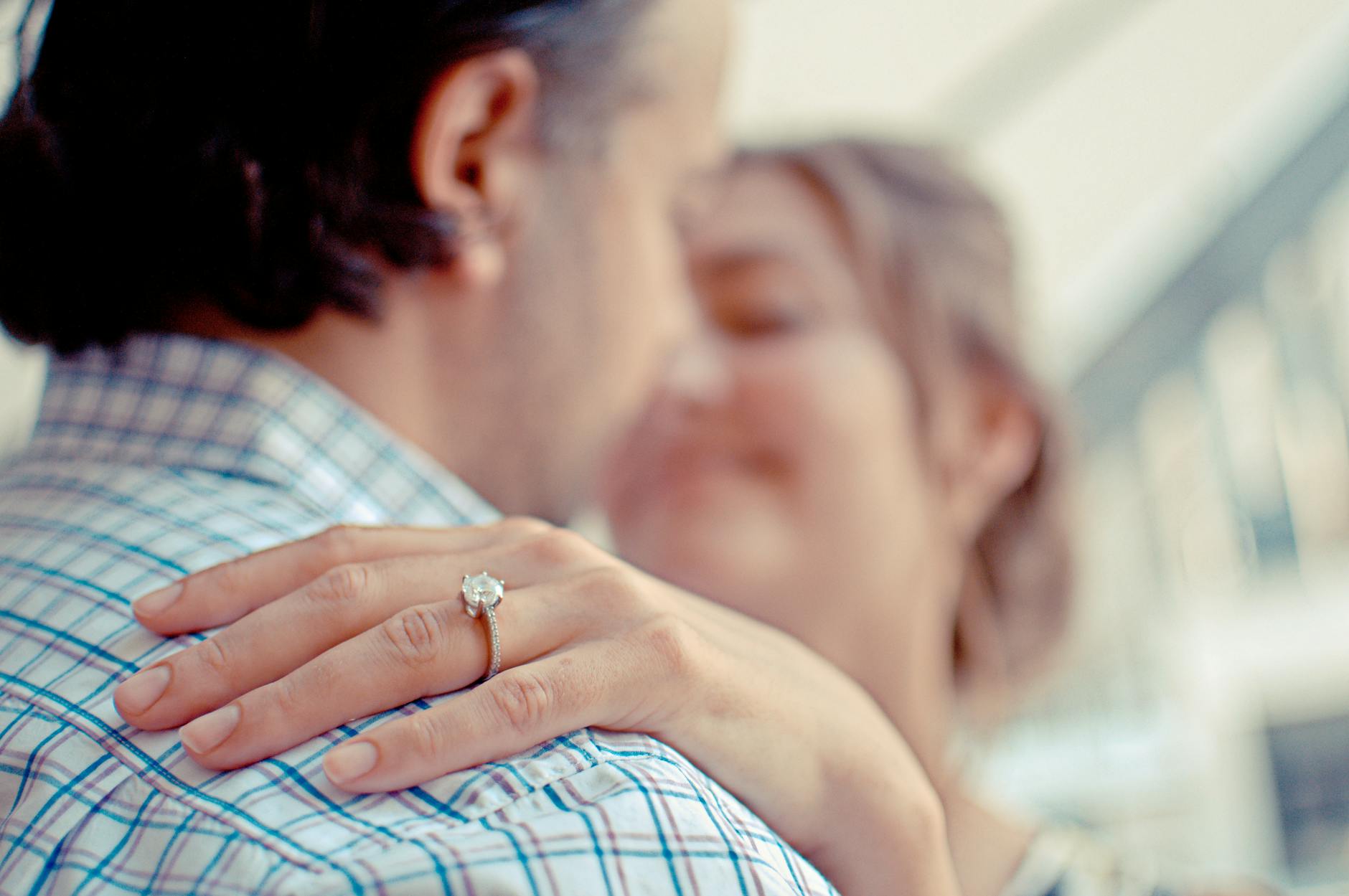 Close-up of an engaged couple, highlighting a diamond ring, symbolizing love and commitment. - rekindle marriage intimacy