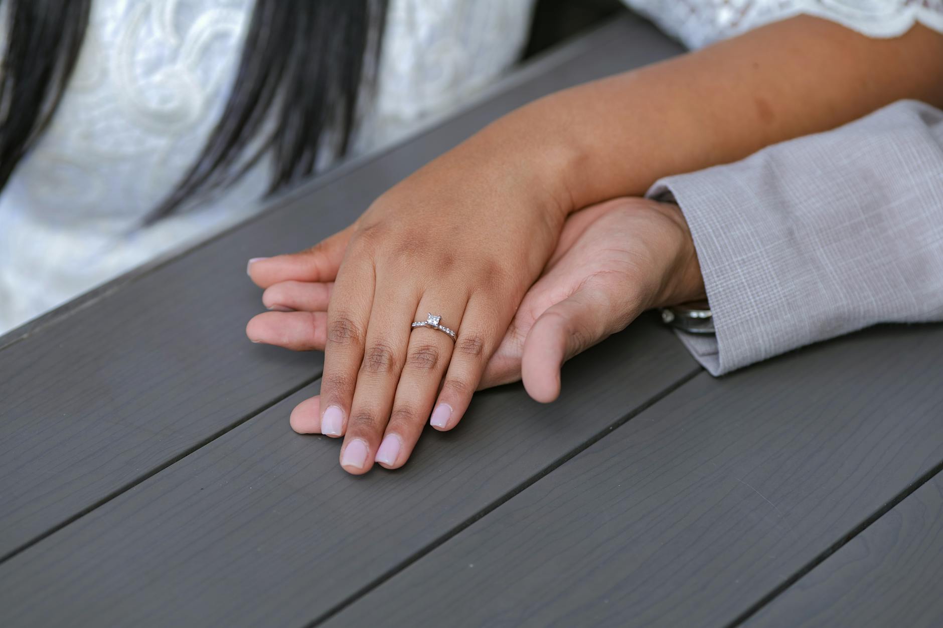 A romantic image showing a couple's hands with an engagement ring on a woman's finger, symbolizing love and commitment. - rekindle marriage intimacy