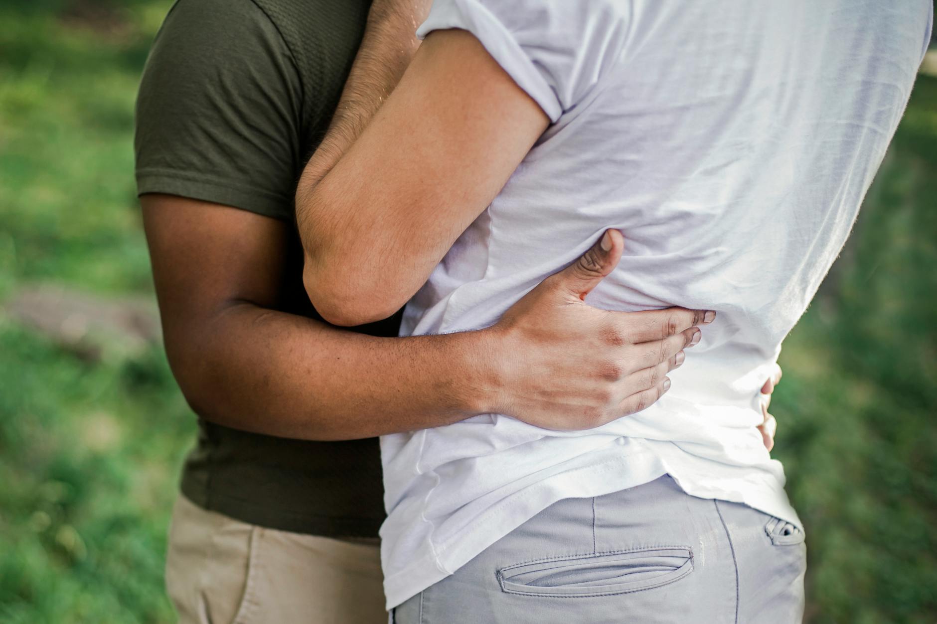 Heartfelt embrace between a diverse couple in lush outdoor setting. - rekindle relationship connection