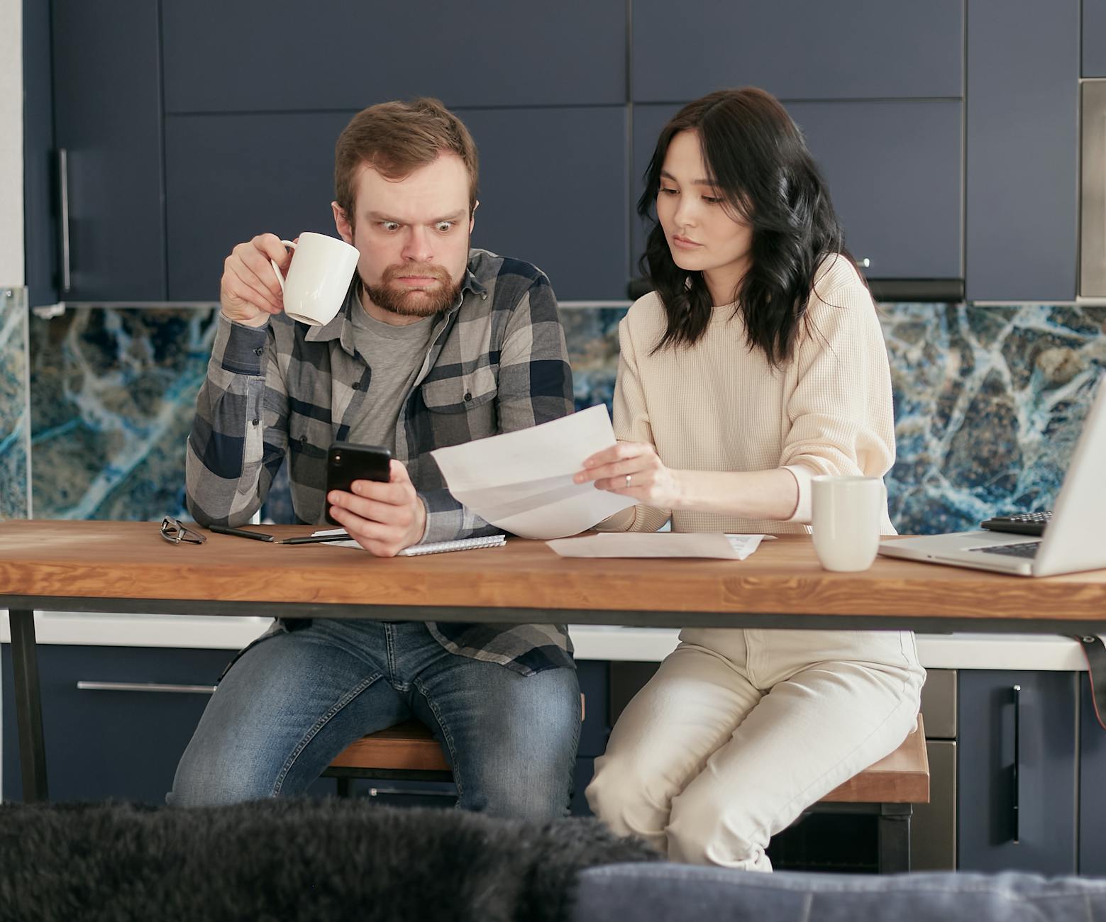 A couple looks concerned while reviewing financial documents together at home. - relationship anxiety spring