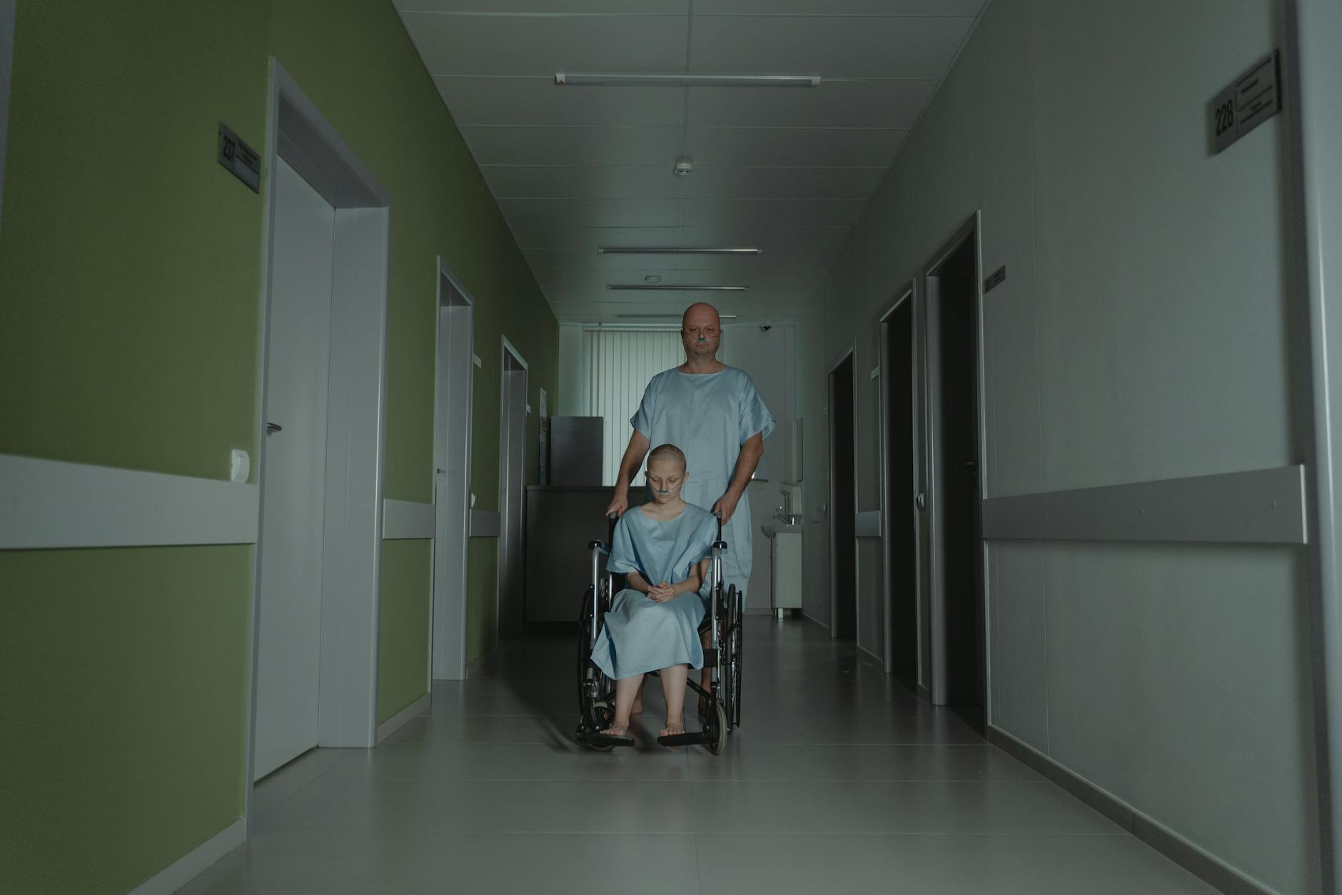 Two patients in hospital gowns navigate a hallway, symbolizing struggle and resilience. - sad cbt treatment
