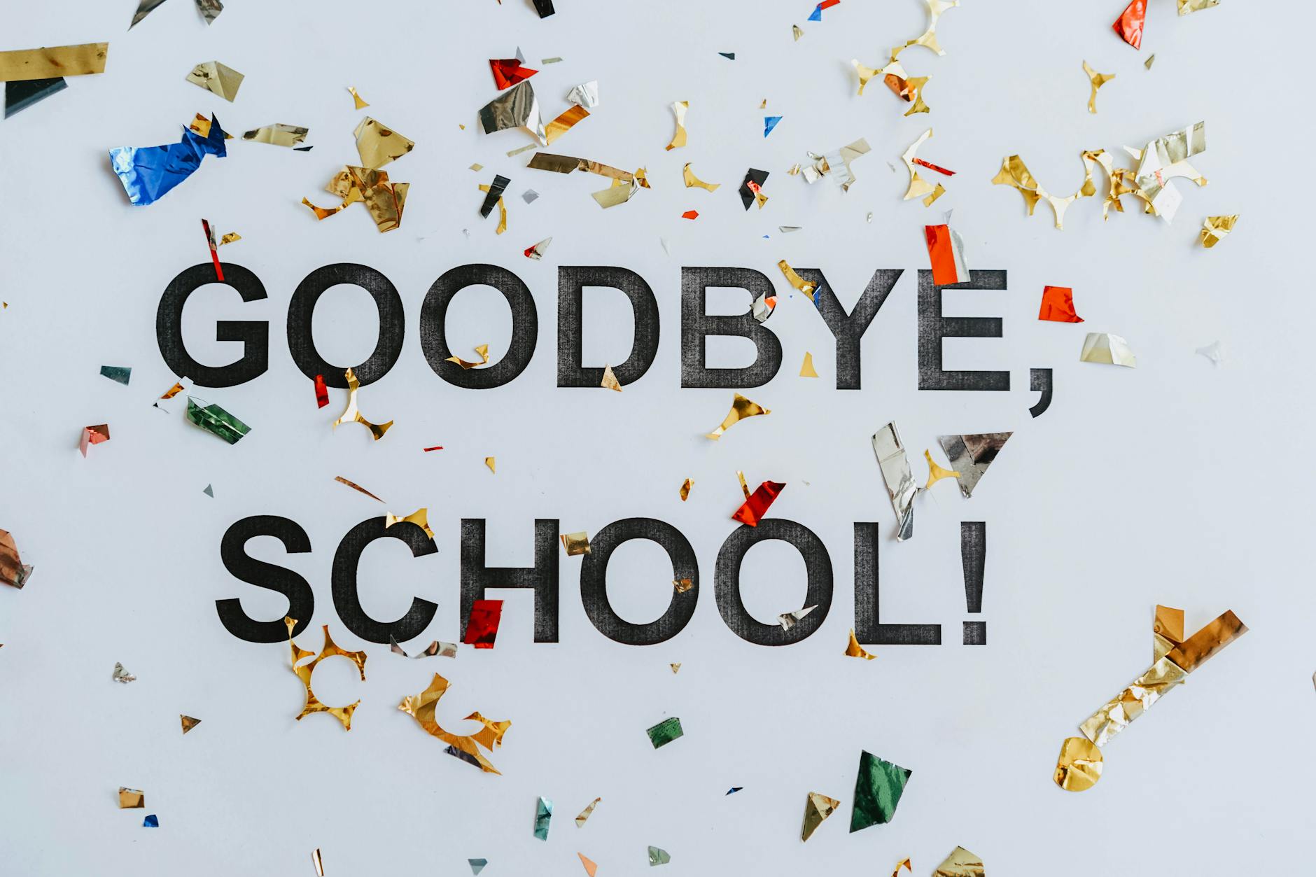 Colorful confetti surrounds a goodbye school message, celebrating graduation. - school break transition