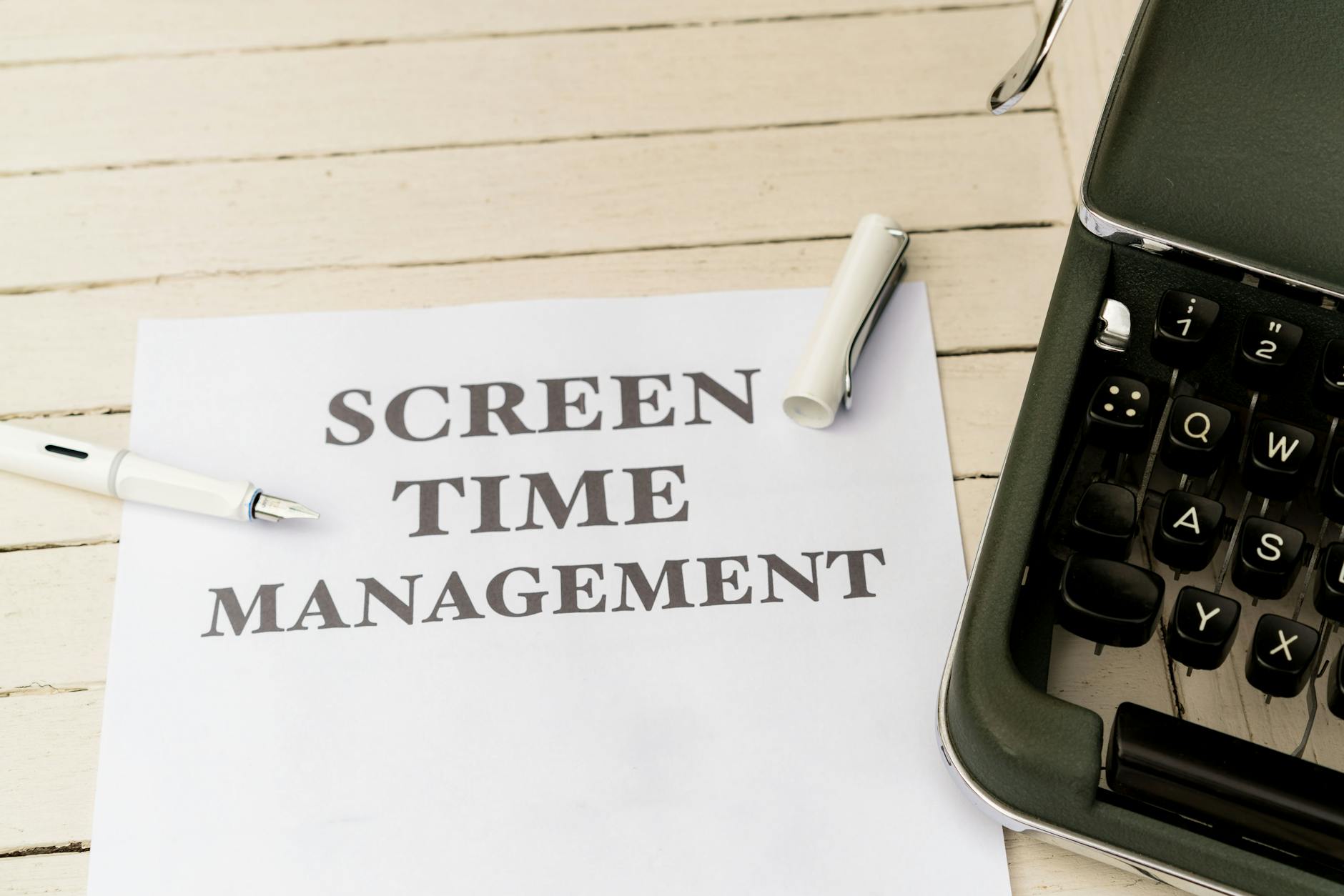 Typewriter with paper titled 'Screen Time Management' on a wooden table. - screen time balance