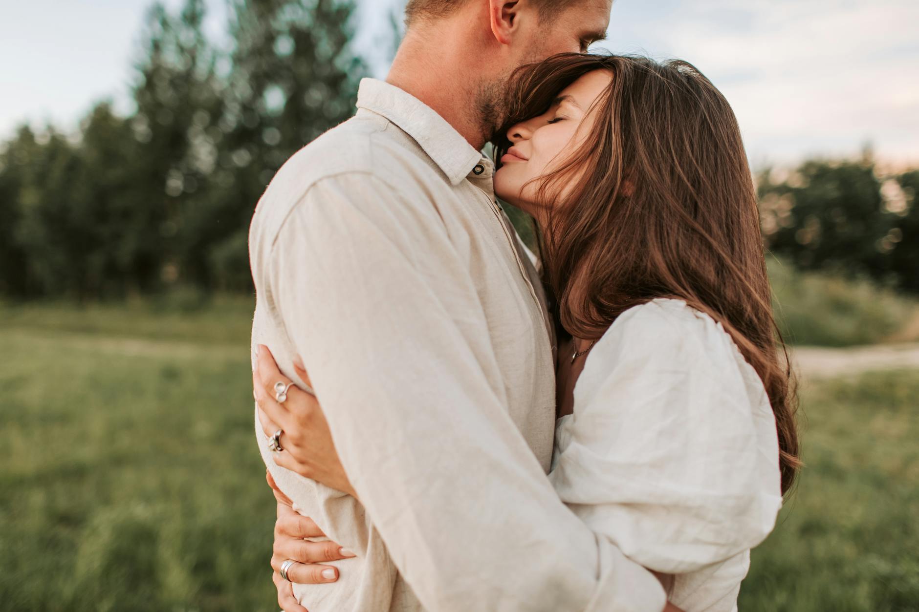 A loving couple shares an intimate embrace in a serene outdoor setting, symbolizing affection and connection. - secure attachment style
