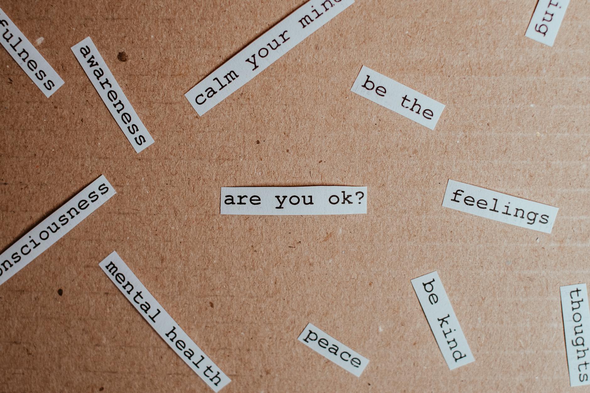 Cut-out words promoting mental health awareness on cardboard background. - self compassion spring
