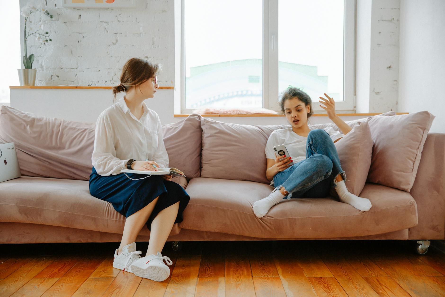 A therapist and a teenager engage in a counseling session on a comfortable sofa. - social anxiety therapy