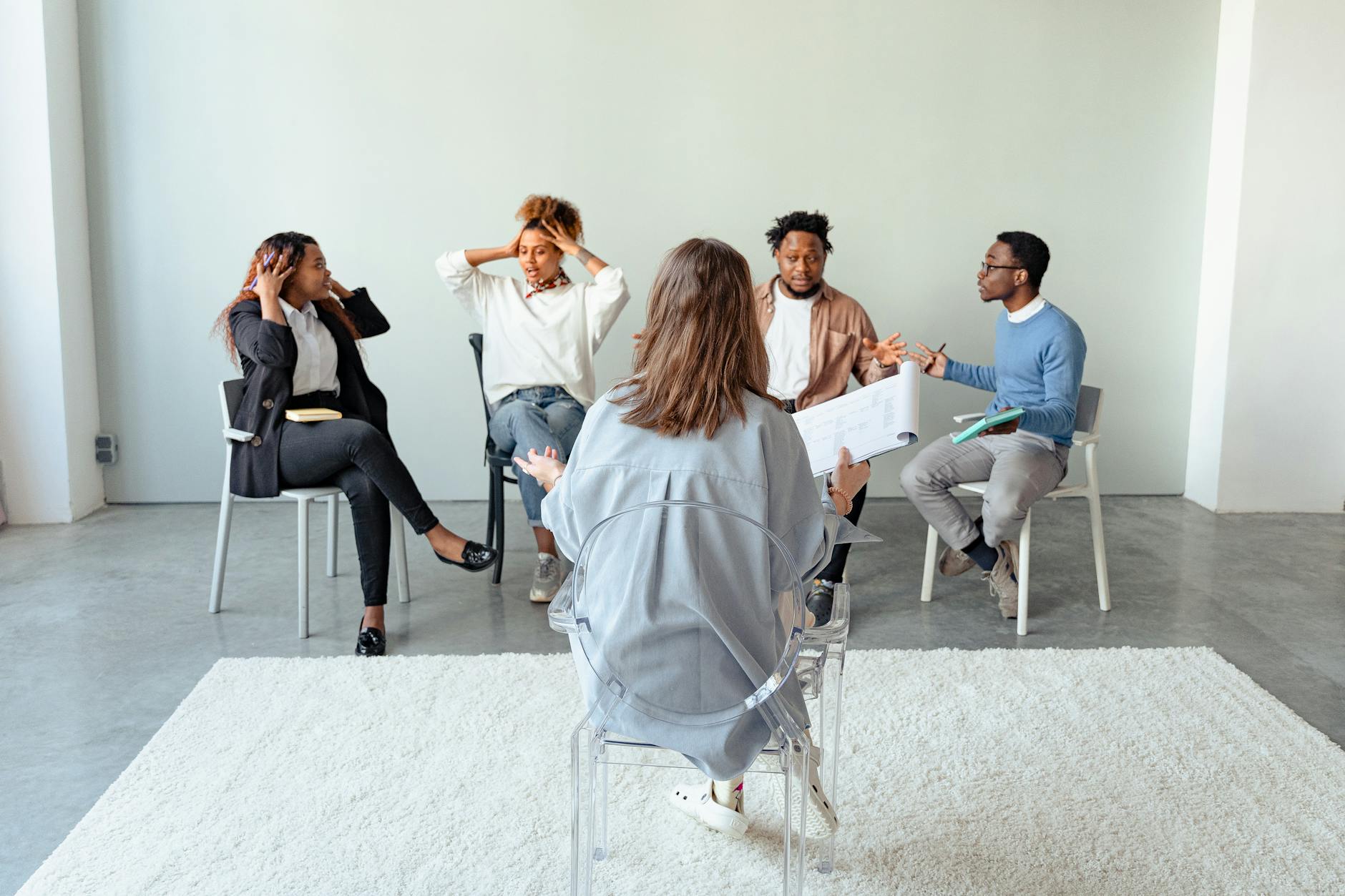 People engaging in a group therapy session indoors, discussing mental health topics. - social anxiety therapy