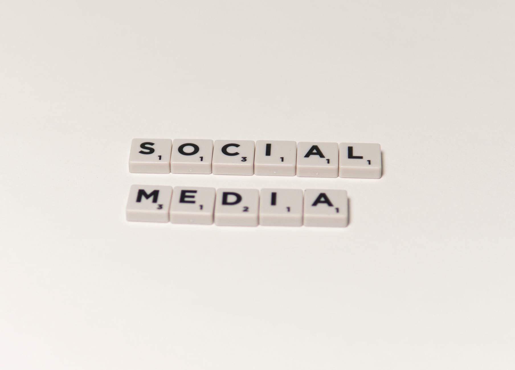 Scrabble tiles spelling 'social media' on a white background, representing digital communication concepts. - social media mental health