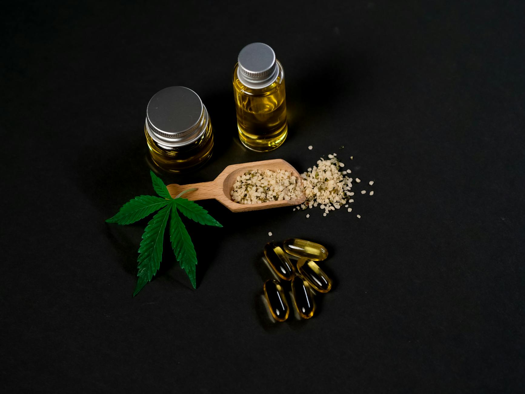 High-quality cannabis oil and capsules with hemp seeds and leaf on a dark backdrop. - spring anxiety relief