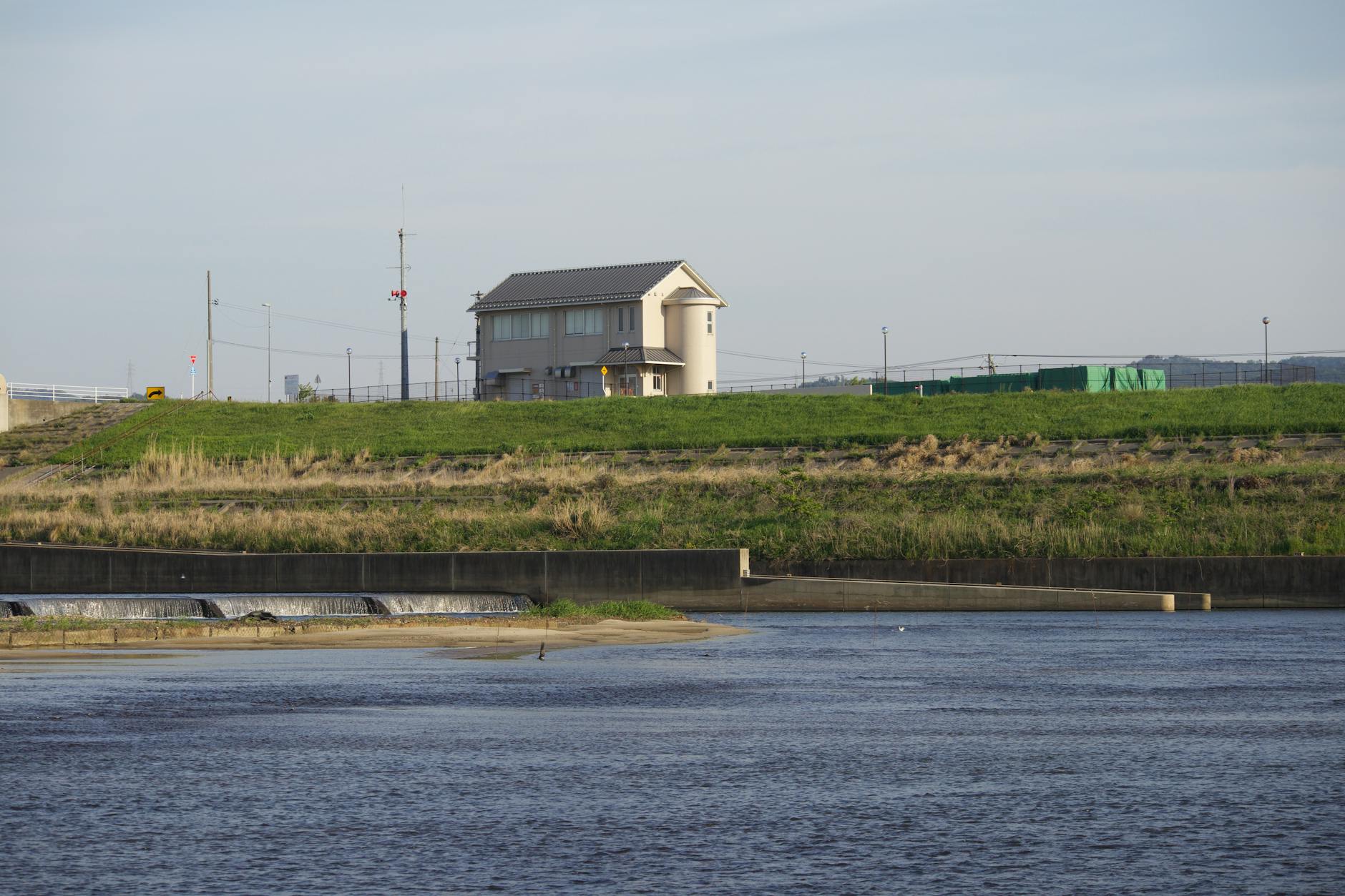 A peaceful countryside river view with a house and weir in spring sunshine. - spring break family boundaries