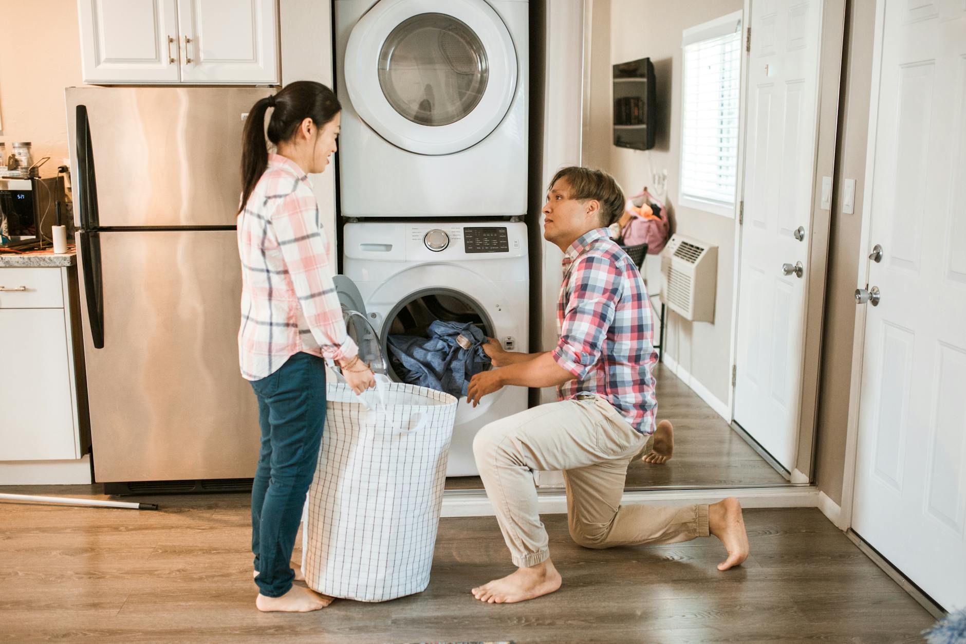 Couple managing household chores by doing laundry in a home setting. - spring chore division