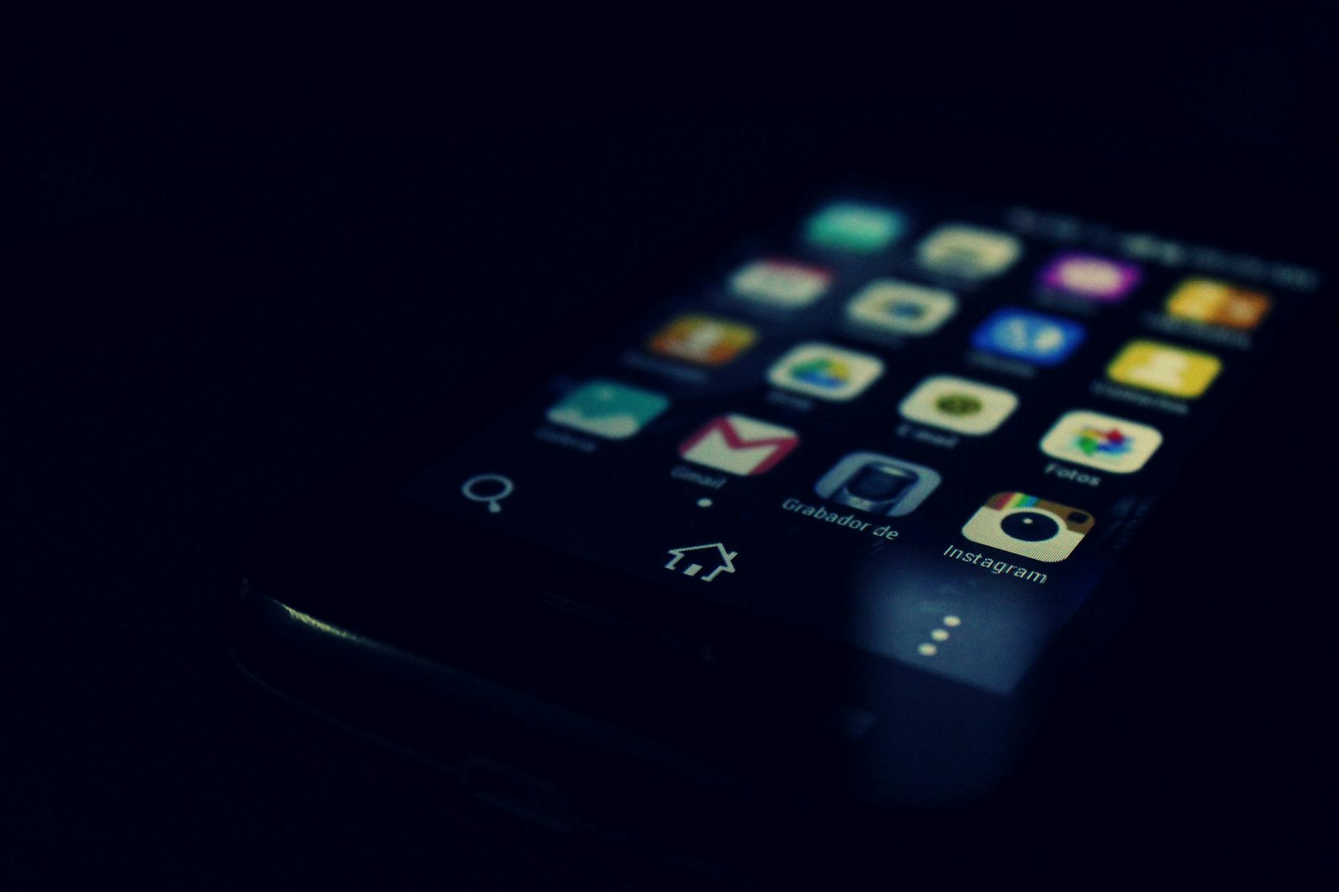 Dark-themed close-up of a smartphone screen highlighting various apps and touchscreen technology. - spring dating app